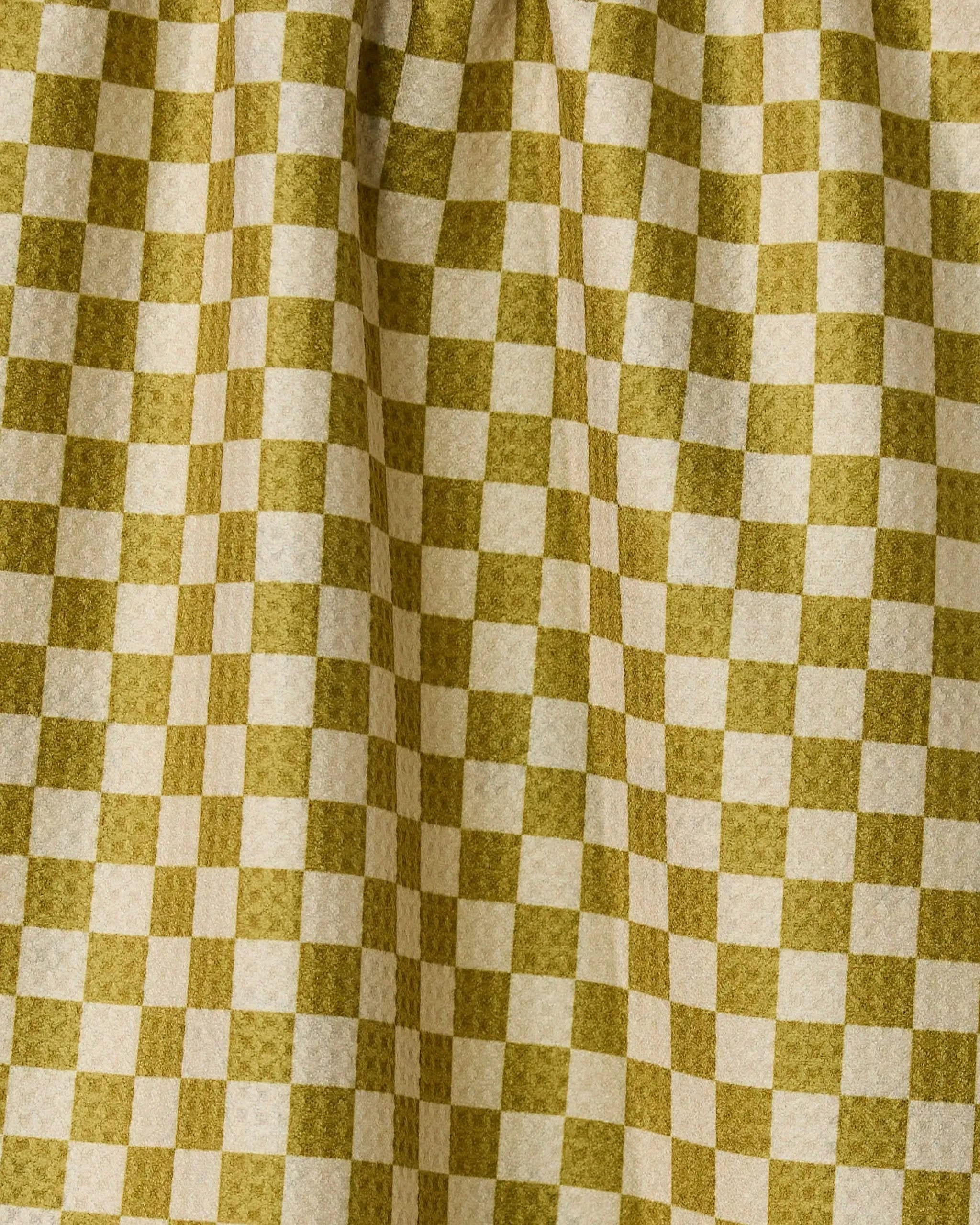 The Zebra Way by Geometry features yellow and cream checkered fabric with soft folds and depth. This double-sided tea towel is both stylish and practical, making it a perfect addition to your kitchen.