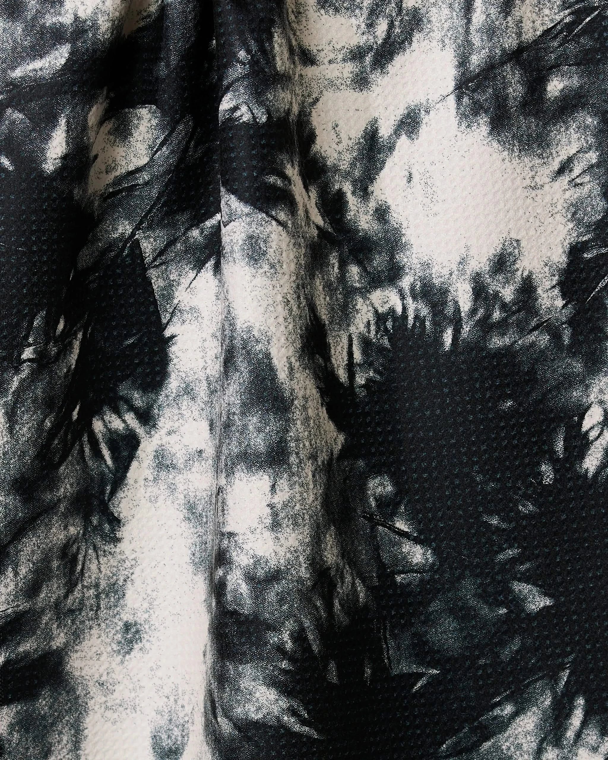 Potion by Geometry features black and white abstract ink wash patterns with a subtle dotted texture, evoking a marble effect. This ultra-absorbent tea towel combines style and function for your kitchen.