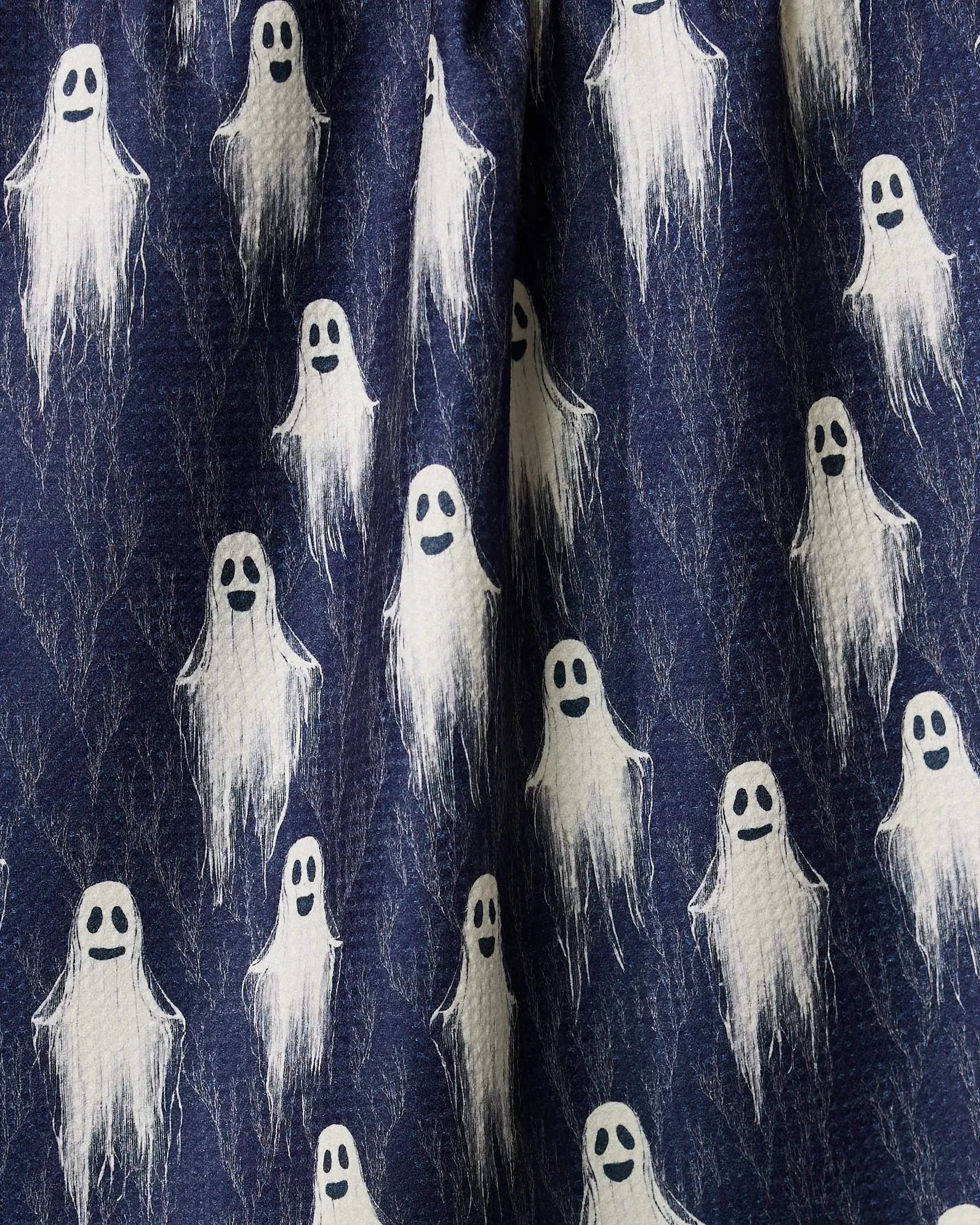 The Geometry Happy Ghosting kitchen tea towel showcases a fun, dark blue design with white cartoon ghosts, each with black eyes and smiling mouths—an ideal way to add playful, spooky charm to your kitchen.