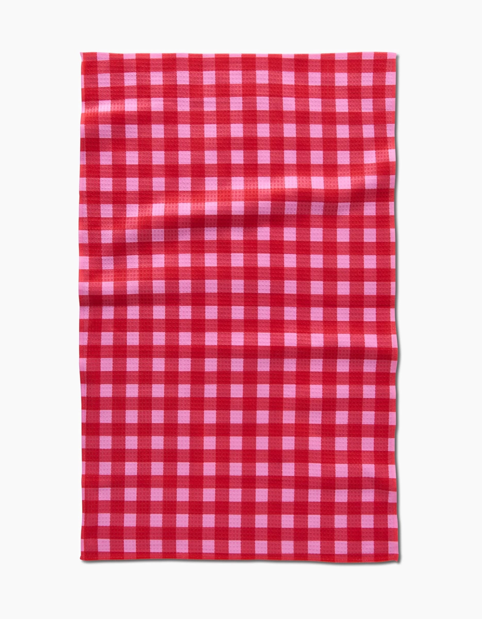 The Cherry Gingham by GEOMETRY is a rectangular cloth featuring a red and white checkered pattern, made with ultra-absorbent Geoweave technology for exceptional performance.