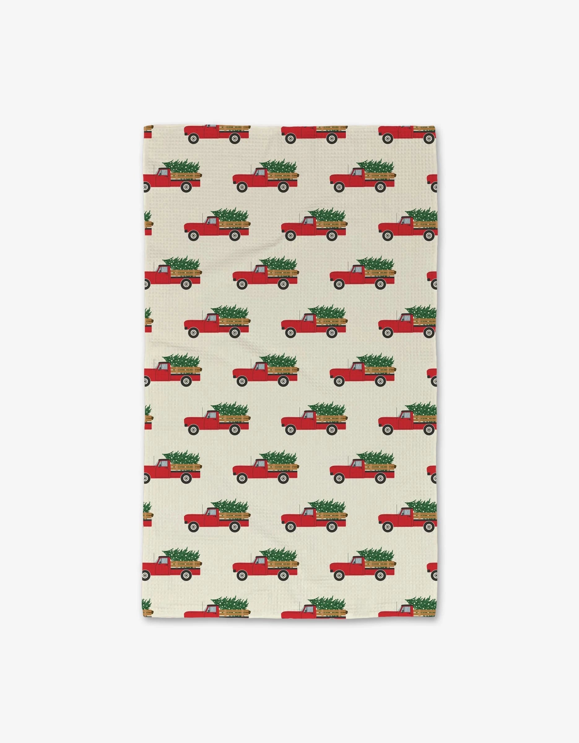 The Christmas Ride hand towel by Megan Kampa features red trucks with green Christmas trees on beige, offering festive style. Ultra-absorbent and made from recycled materials for sustainable holiday cheer.