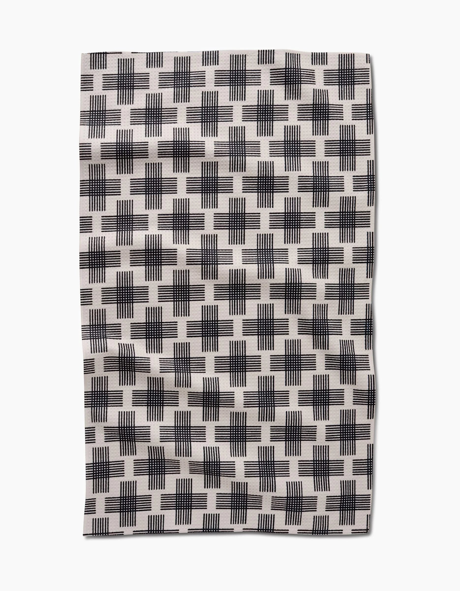 The Cross Hatch by Rosa Kichline is a white rectangular cloth with a black crosshatch grid pattern, slight wrinkles, and ultra-absorbent Geoweave technology.