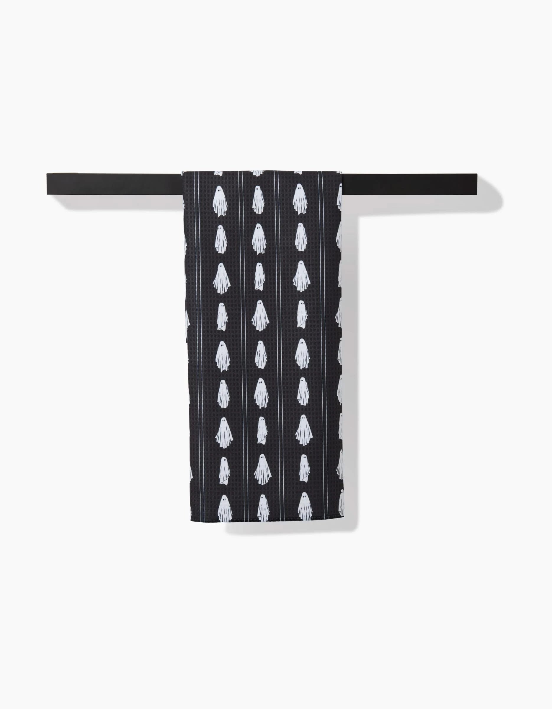 The Aubrey Fairchild Ghost Pinstripes hand towel, featuring white squid patterns, hangs neatly over a black recycled towel bar against a white background.