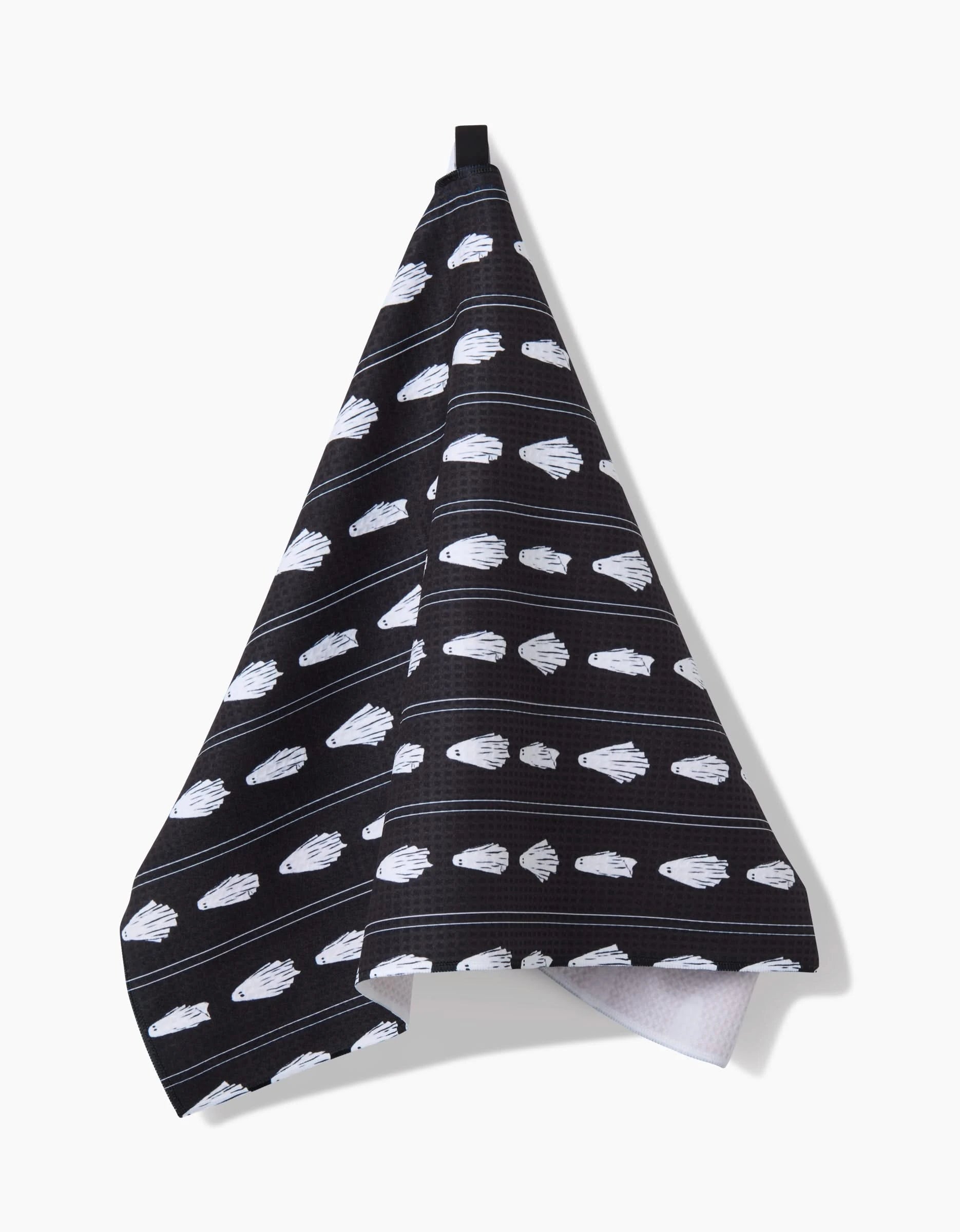 The Ghost Pinstripes hand towel by Aubrey Fairchild, crafted from recycled materials, displays black fabric with white illustrated hands in various poses and hangs from a black loop against a plain white background.