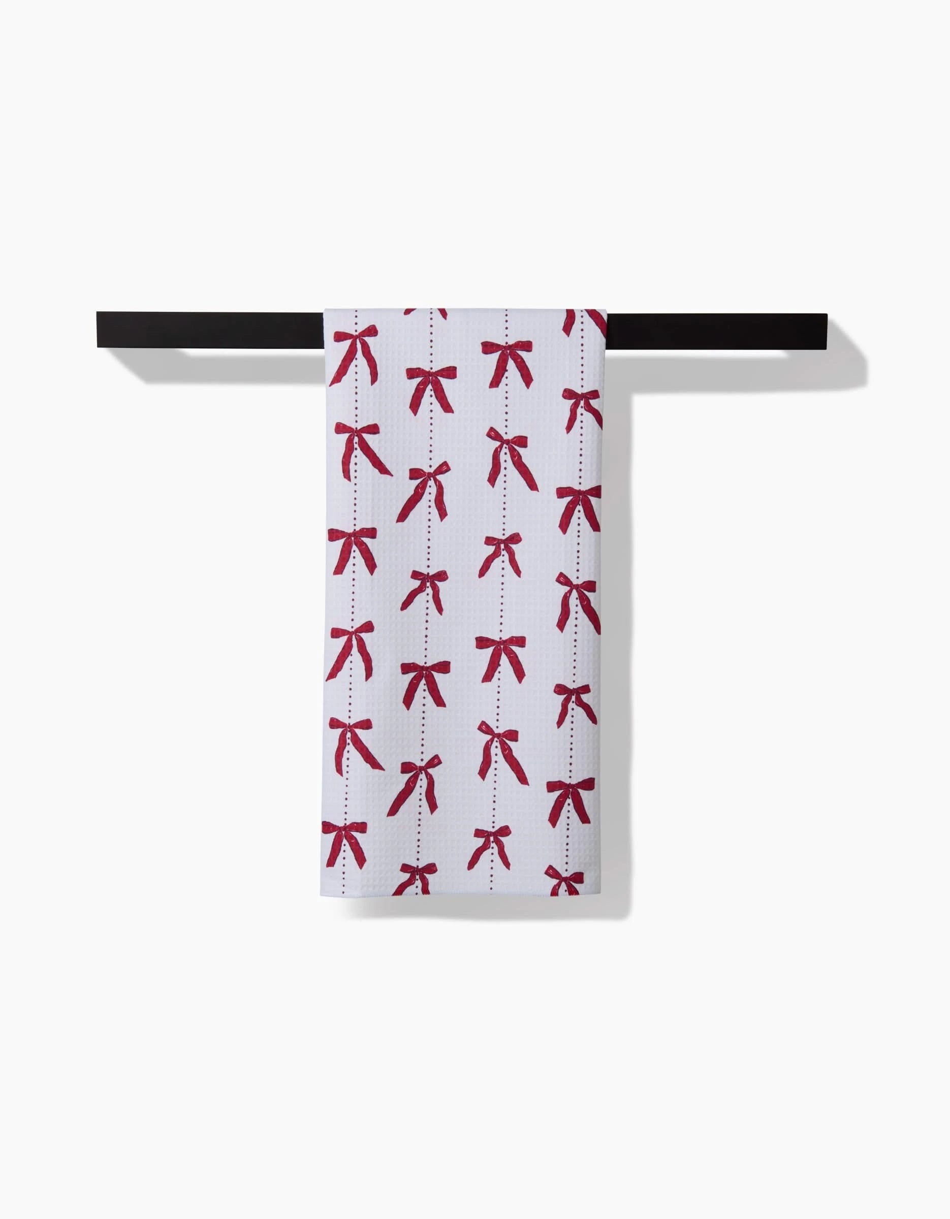 The Little Bows And Pearls Luxe Hand Towel by Hufton Studio features a red bows pattern and hangs on a black rod. Its Geoweave technology makes it quick-drying and ideal for any modern space.