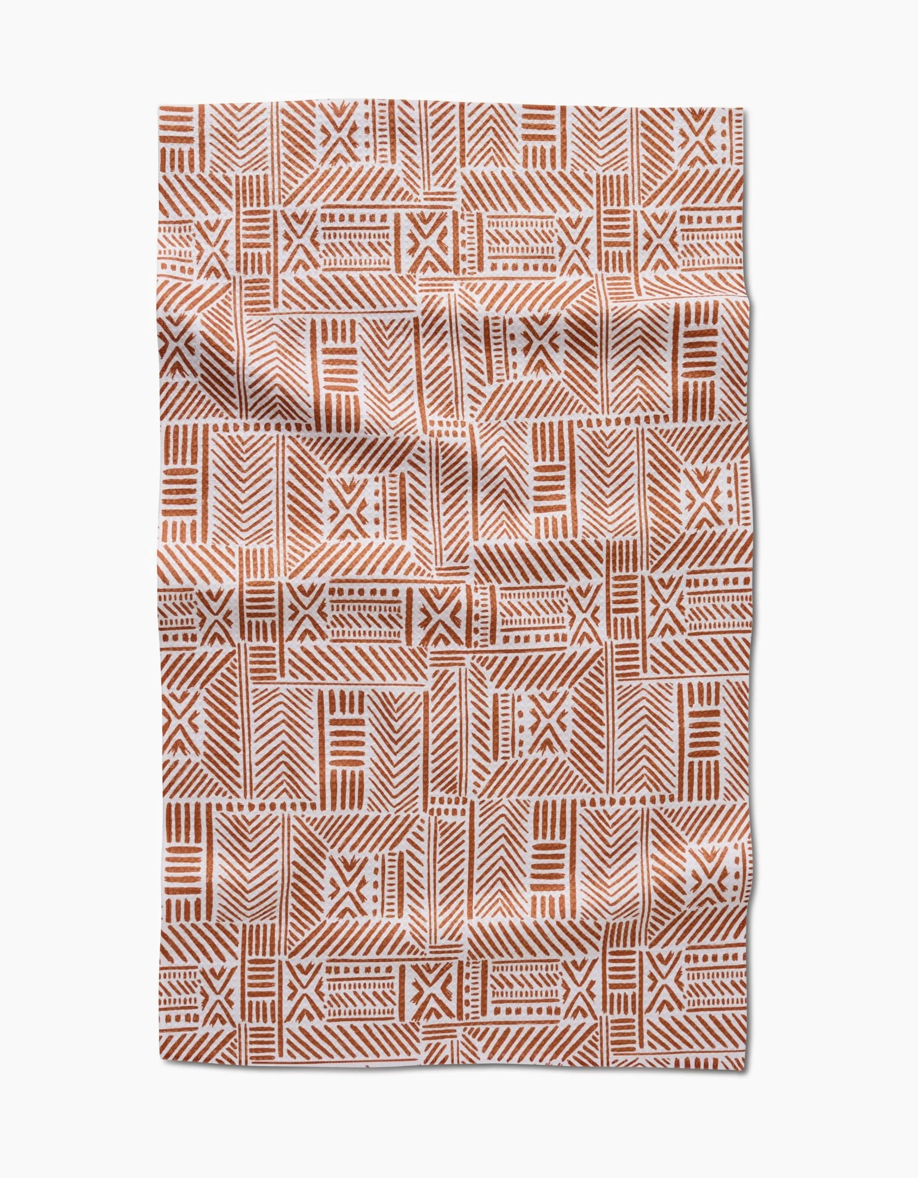 The Hufton Studio Mud Cloth Natural is a rectangular cloth with a rust and white geometric tribal pattern of lines, dots, and crosses. Made using Geoweave technology, it’s ultra-absorbent with a slightly wrinkled look.