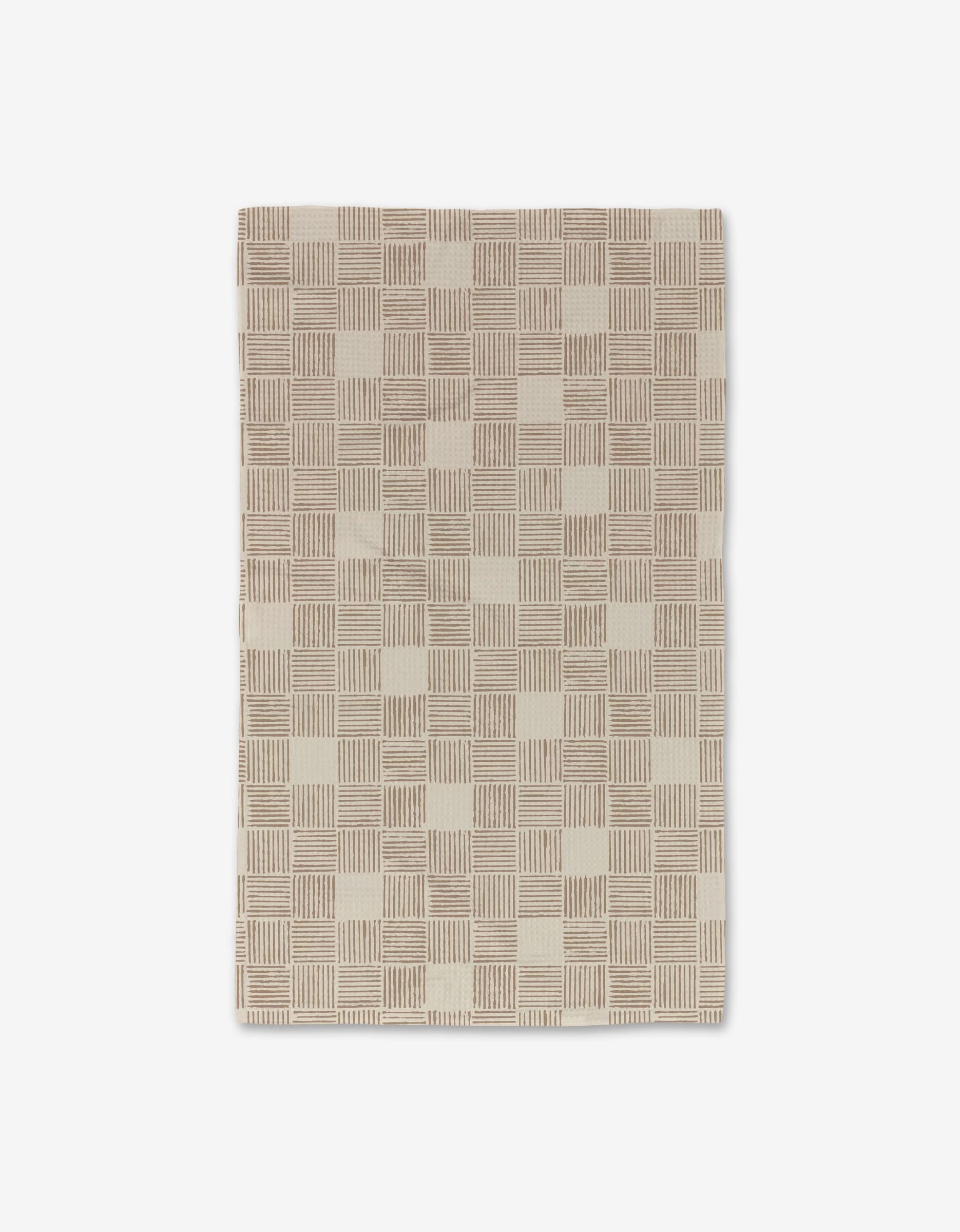 The Thatcher rug by Studio Jeannot features a white background with a checkered pattern of beige and cream squares, each displaying thin, textured lines for an ultra-absorbent feel inspired by Geoweave technology.