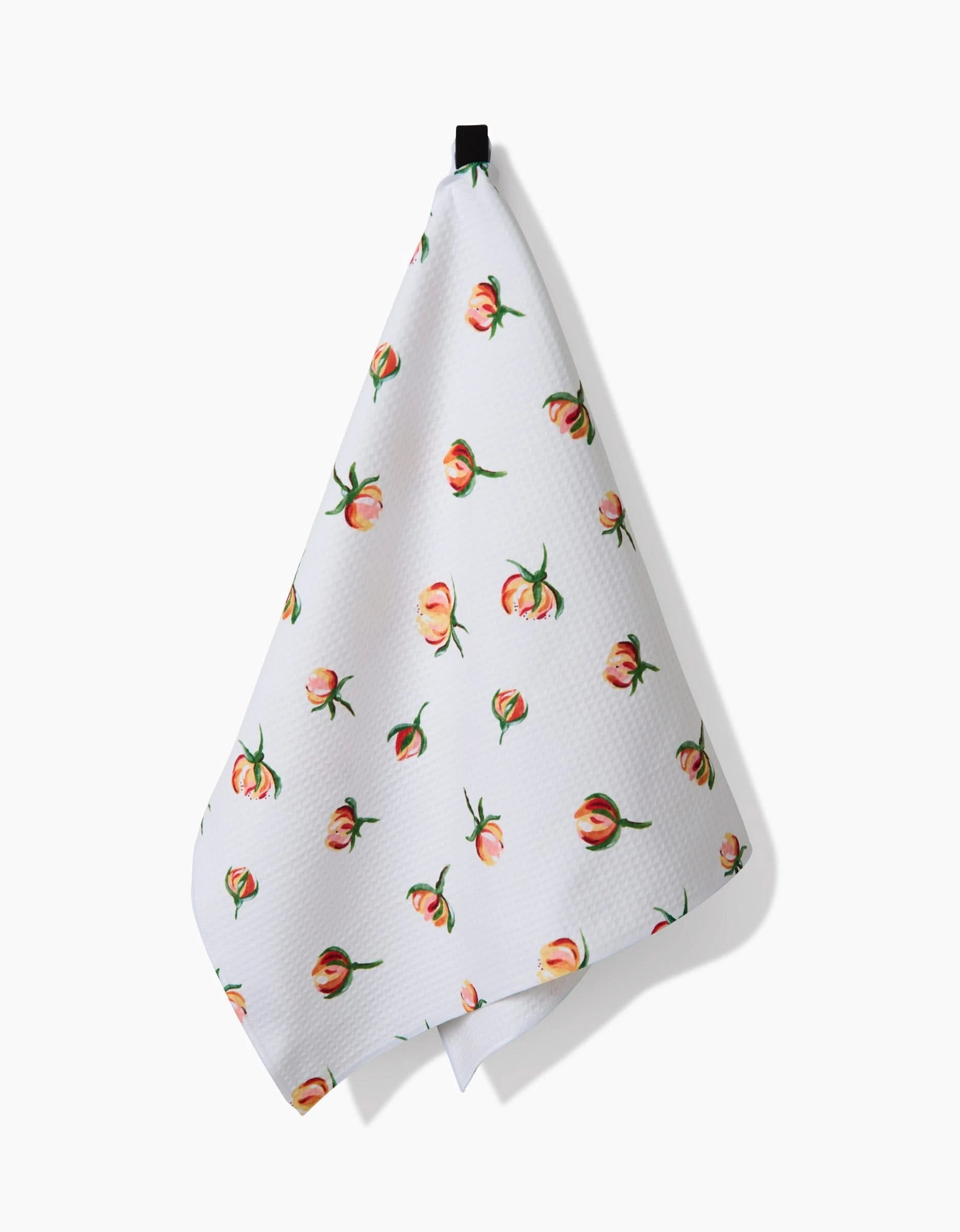 A white textured Luxe Hand Towel, Linda Fox’s Yellow Rosebuds, featuring a colorful rosebud pattern, ultra-absorbent and quick-drying, hangs from a black loop against a plain white background.