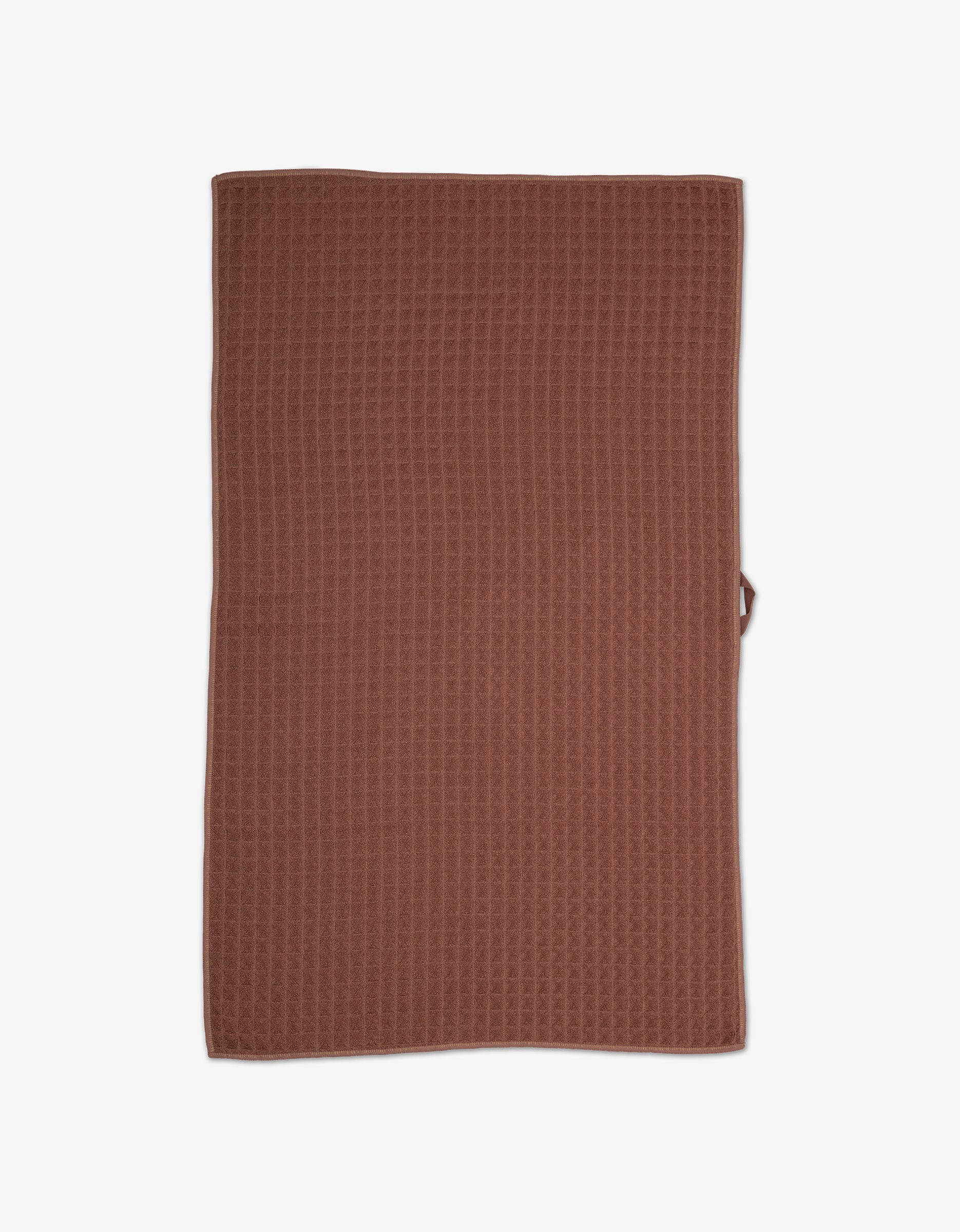 The GEOMETRY Dusty Rose hand towel features a rectangular, brown textured waffle weave. Ultra-absorbent and stylish, its perfect for elevating your bathroom essentials. Shown laid flat on a white background.