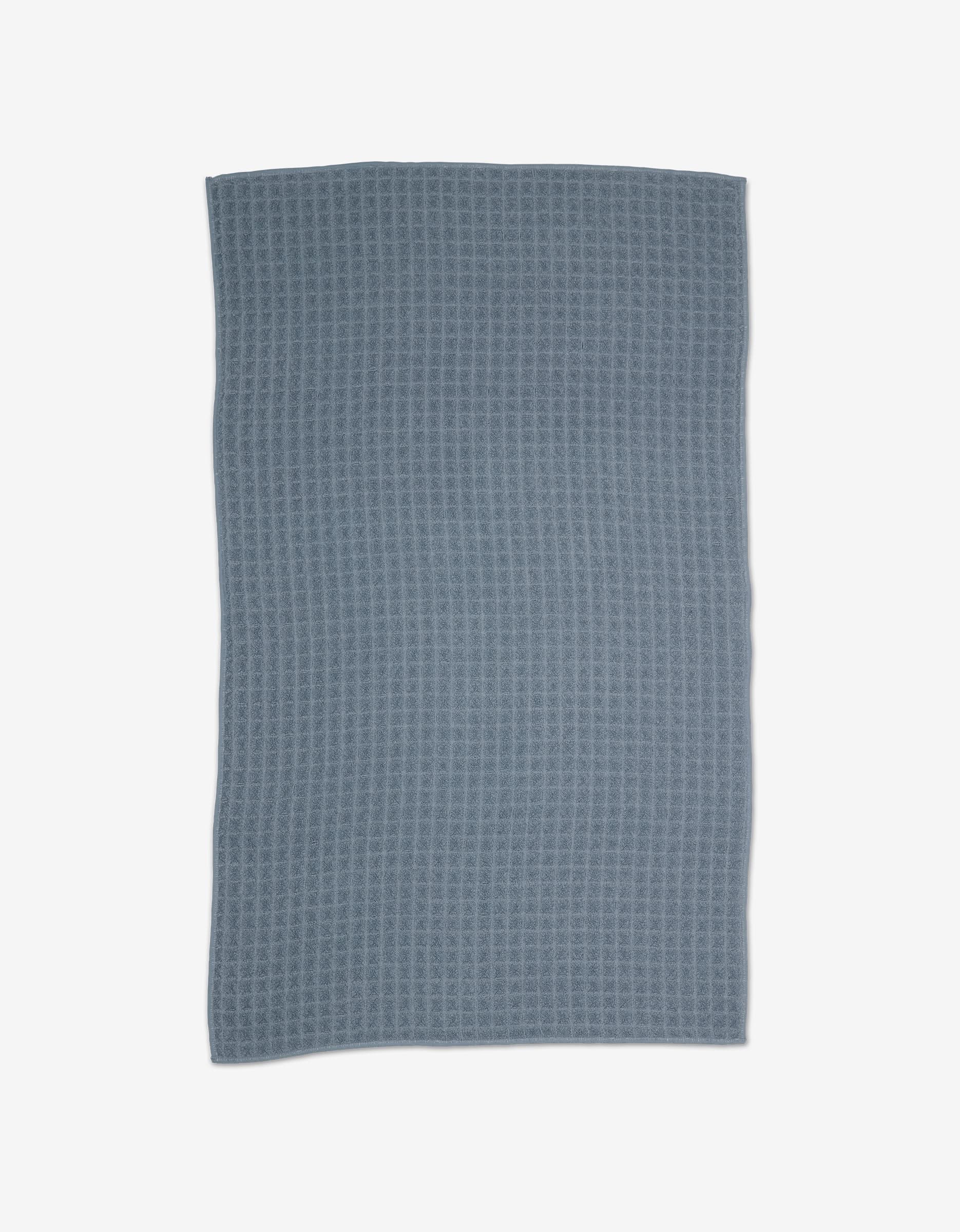 The GEOMETRY Sky Hand Towel is rectangular and blue-gray with a subtle waffle pattern, slightly uneven edges, and an ultra-absorbent texture—providing everyday luxury when laid flat on a white background.