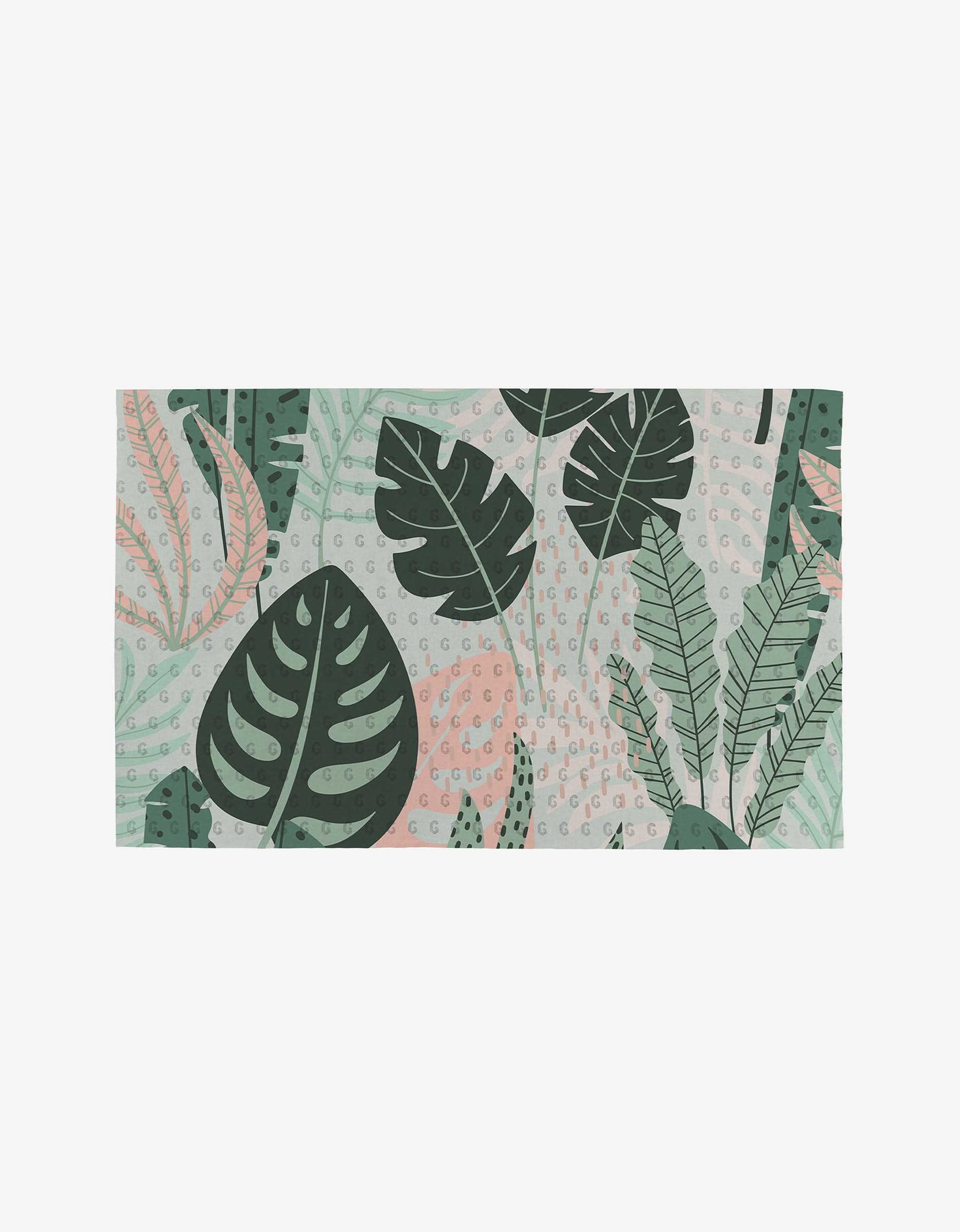 The GEOMETRY Artistic mat is rectangular, made from eco-friendly materials, and features large green tropical leaves with pink accents and small dotted details on a light background.
