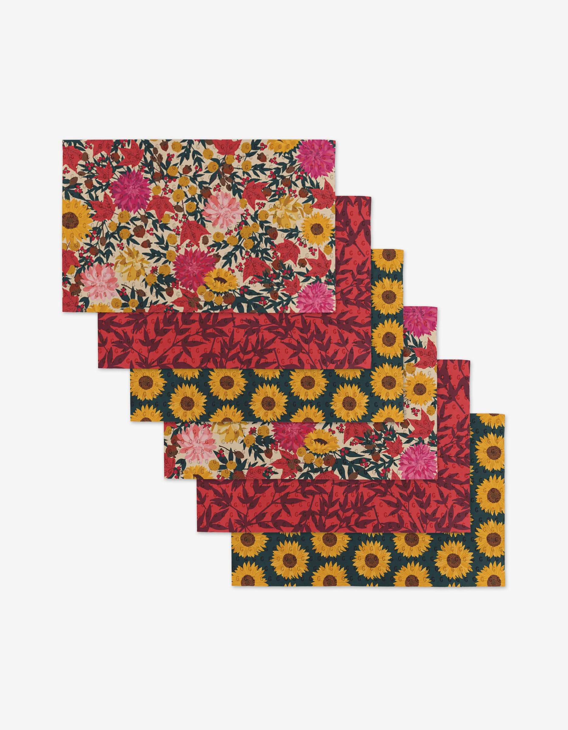 Five rectangular placemats from Rebecca Bobkos Autumn Florals collection are arranged in a staggered stack, each with vibrant sunflower and floral patterns, offering an eco-friendly alternative to Not Paper Towels.