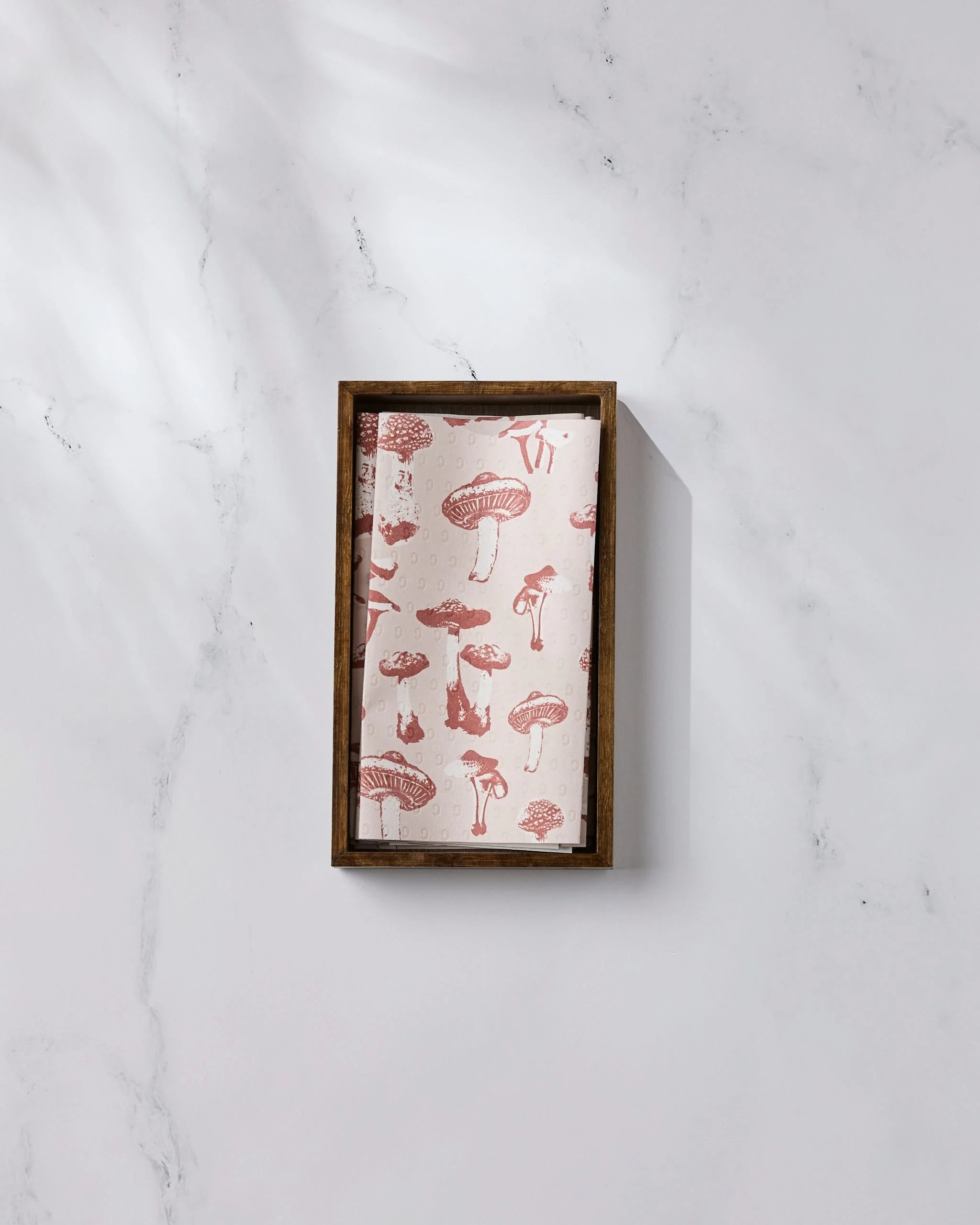 The Geometry Autumn Mushrooms rectangular wooden tray, featuring a pink mushroom pattern, rests on white marble in gentle natural light—ideal for displaying eco-friendly kitchen towels or reusable paper towels.