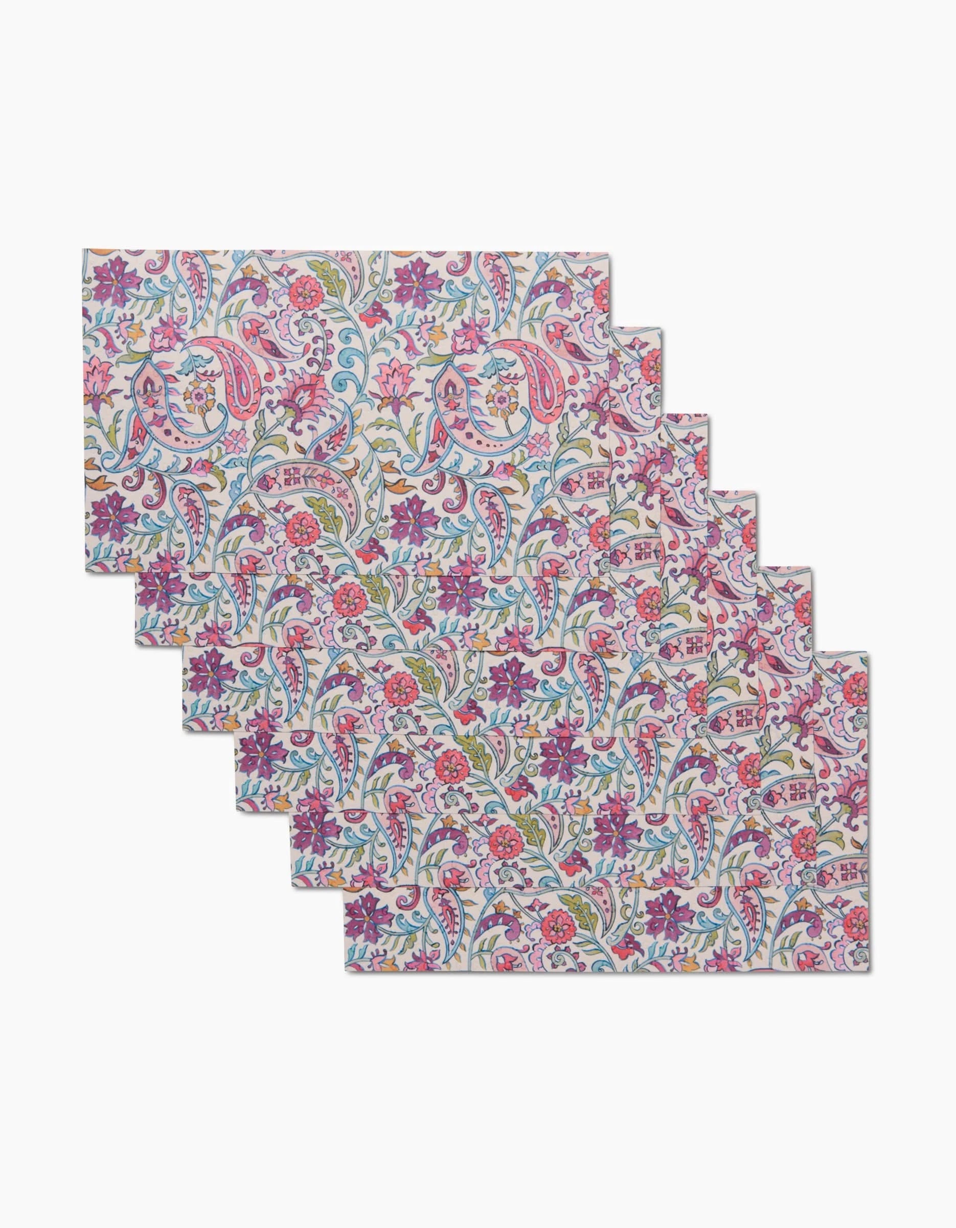 The Bazaar placemats by Maayan Alper-Swan are a set of six reusable rectangular mats featuring vibrant floral and paisley designs in pink, purple, blue, and green—an eco-friendly alternative to paper towels.