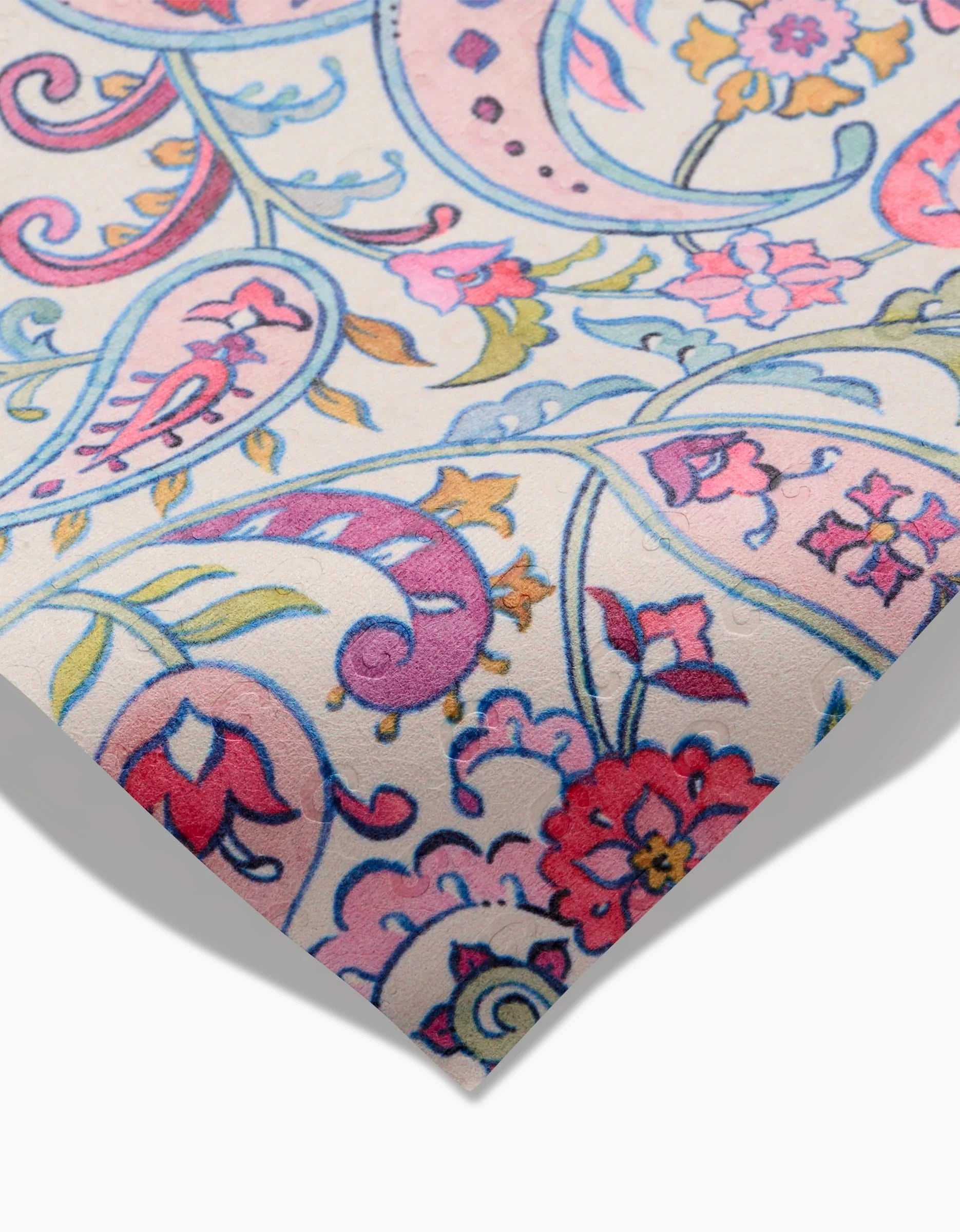 A close-up of Bazaar by Maayan Alper-Swan, a reusable fabric towel featuring vibrant paisley and floral patterns in pink, blue, and purple on a light background. The eco-friendly design is shown with a slightly folded corner.