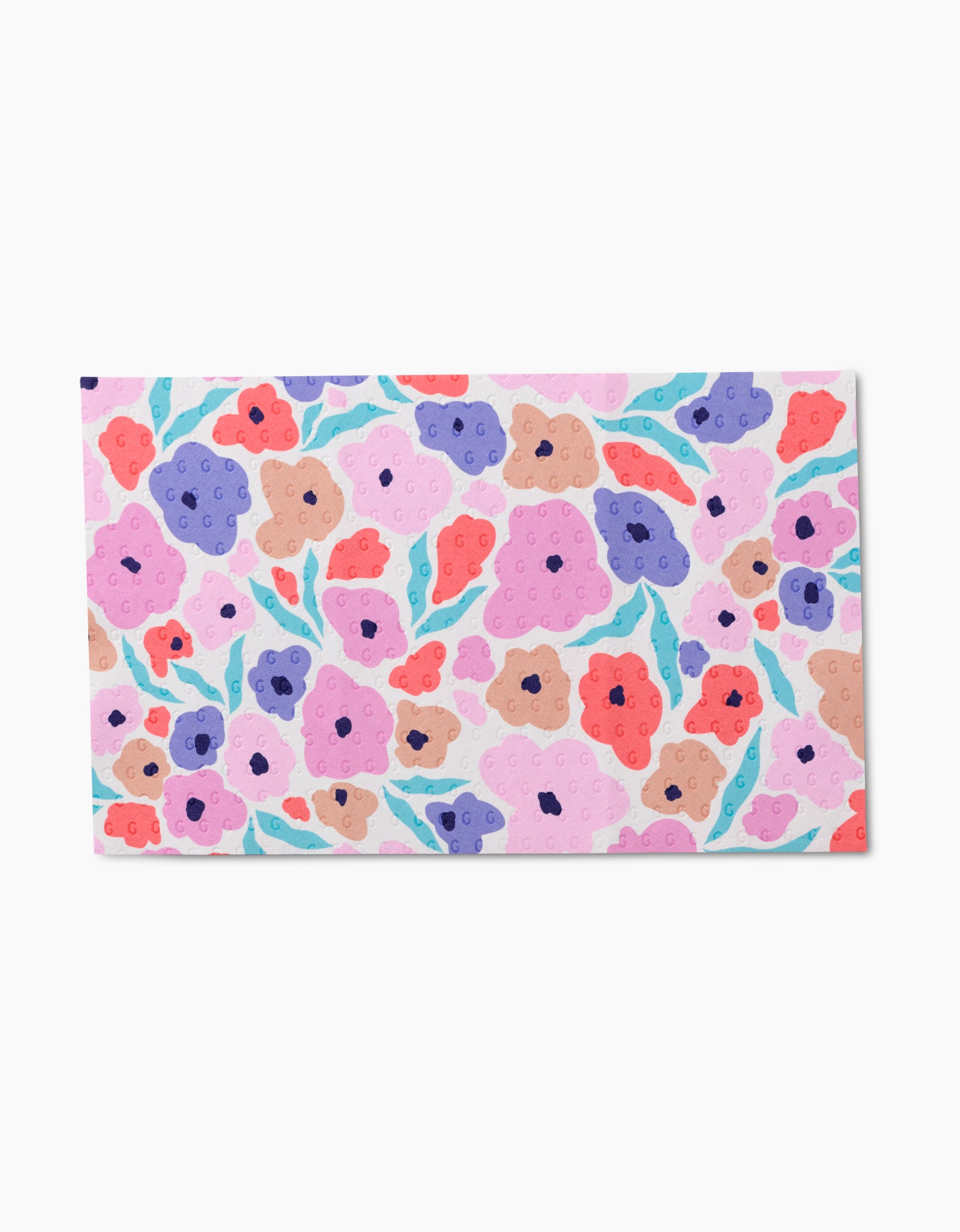 The GEOMETRY Blossoming Love paper showcases a vibrant abstract floral pattern with pink, red, purple, and blue flowers plus green leaves on white, made from eco-friendly post-consumer recycled materials.