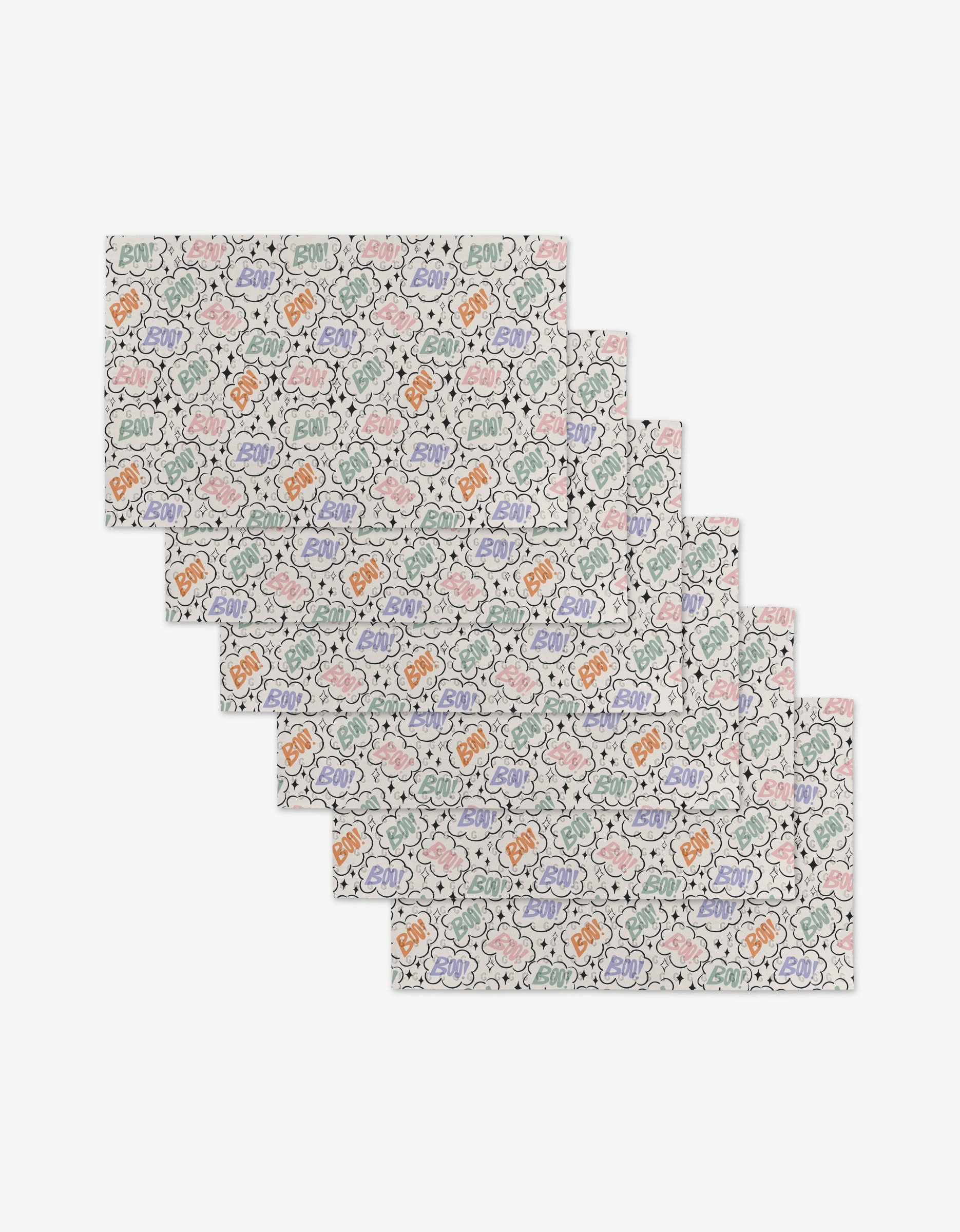 Charlie Rowan Designs Boo Burst set includes six rectangular placemats featuring colorful clouds, lightning bolts, and comic-style BOO! on white. Made from post-consumer recycled materials for an eco-friendly choice.