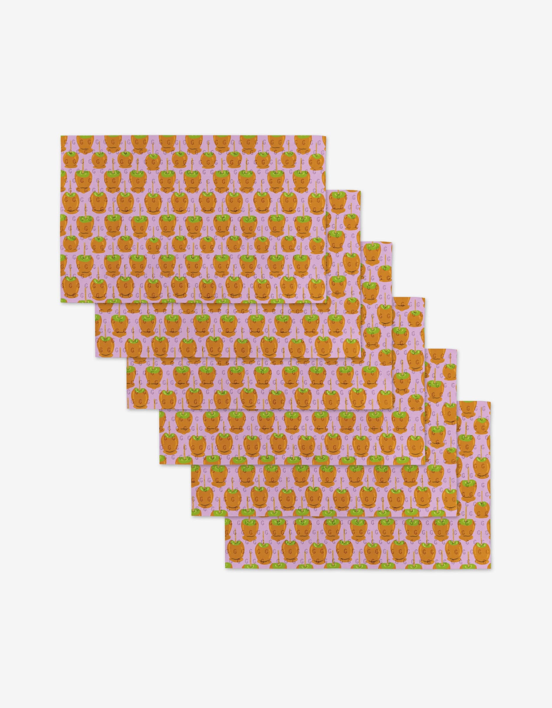 Six rectangular Caramel Apple sheets by Elisabeth Wing—made from eco-friendly, post-consumer recycled materials—feature smiling peaches and green leaves on a light pink background in a staggered, overlapping layout on white.