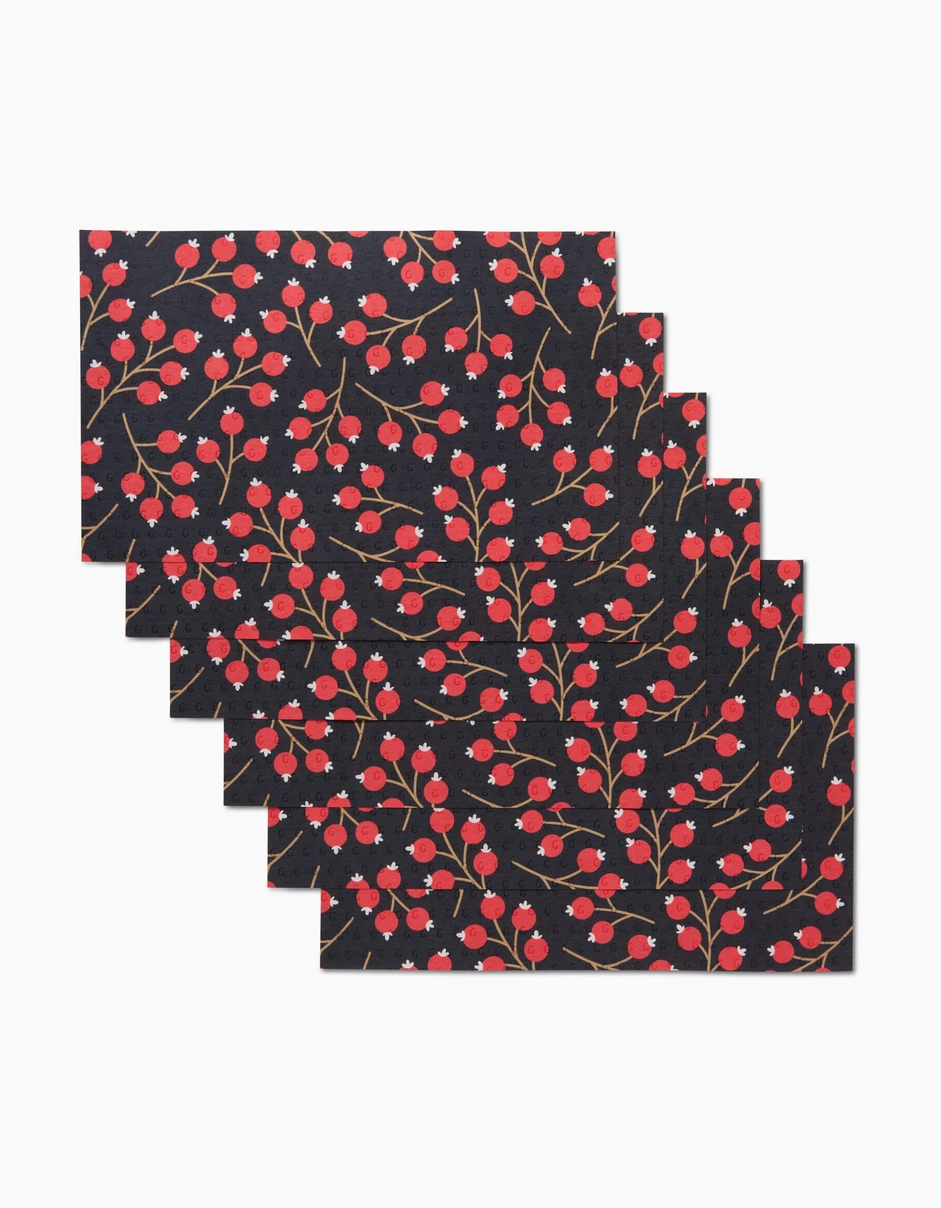 Six machine-washable Megan Kampa Christmas Berries placemats feature a black background with red and green floral patterns, including small red berries and green stems—an eco-friendly alternative to disposable table settings.