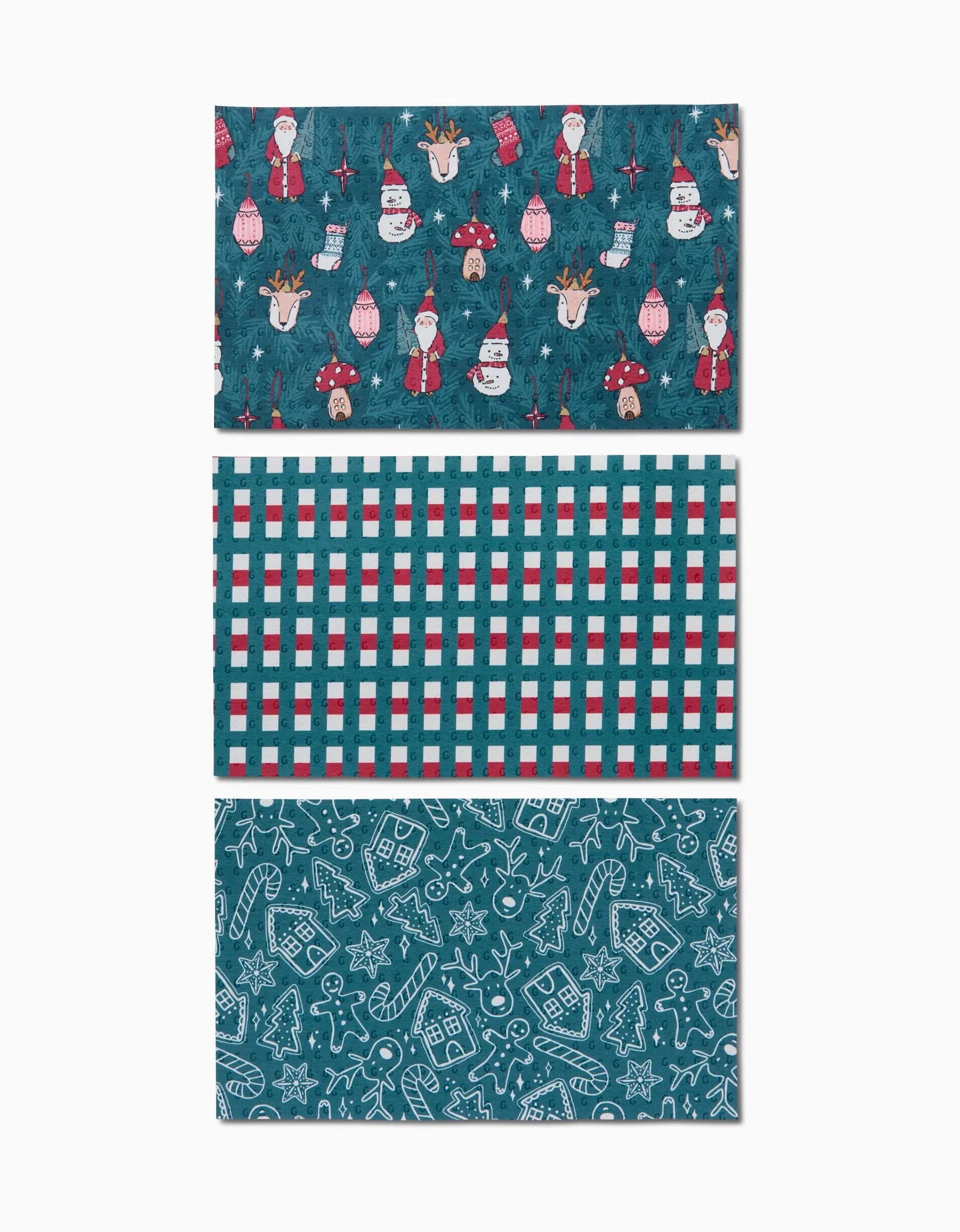 The Christmas Traditions set by Hufton Studio includes three rectangular sheets: one with festive characters, one red-teal-white plaid, and one with white holiday doodles on teal—ideal for wrapping reusable paper towels as gifts.