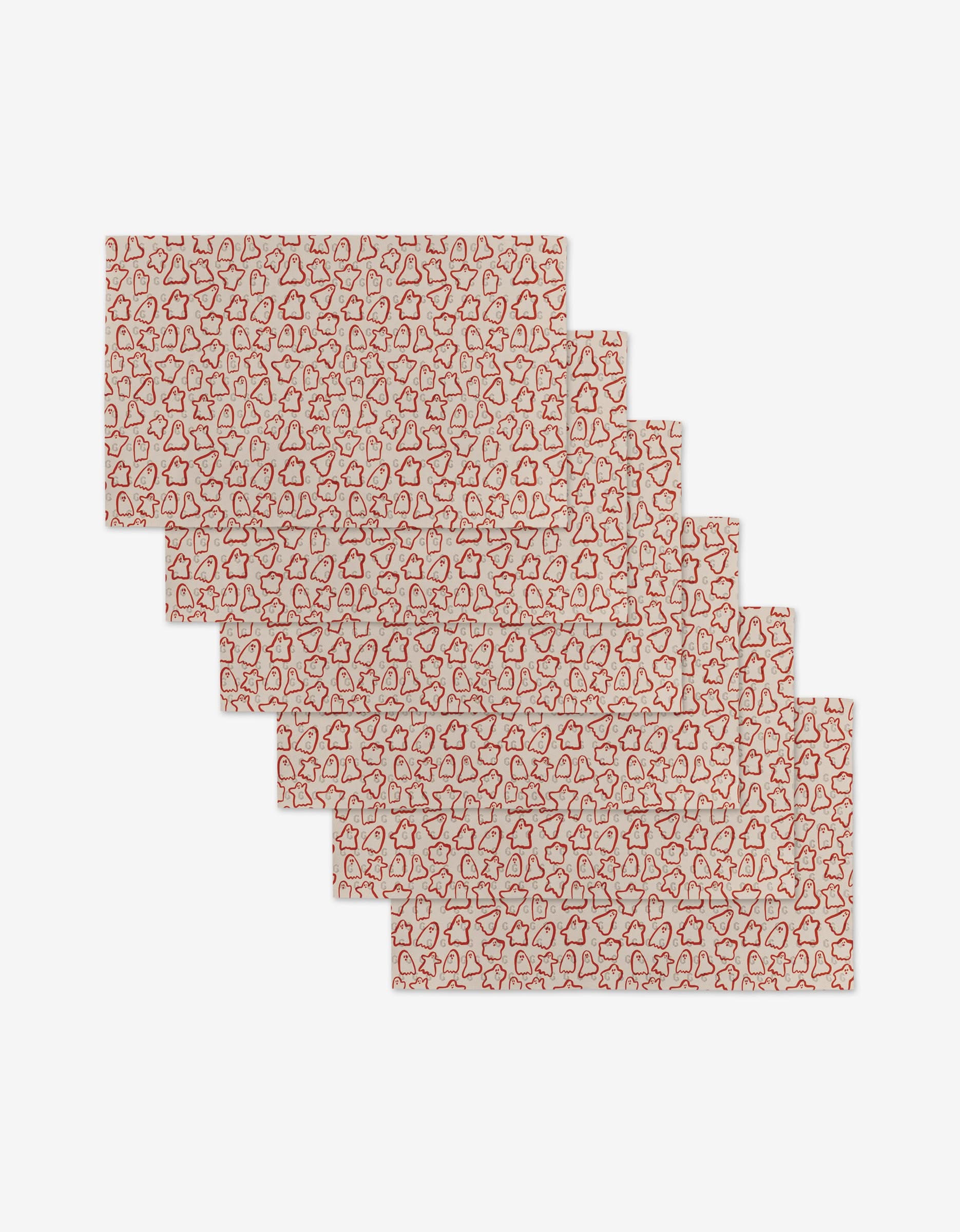 Six rectangular placemats by Kayla Ann, Cute Ghosts, are made from recycled materials and feature a white background with an all-over red outline pattern of stars, trees, and gingerbread men arranged in a staggered stack.