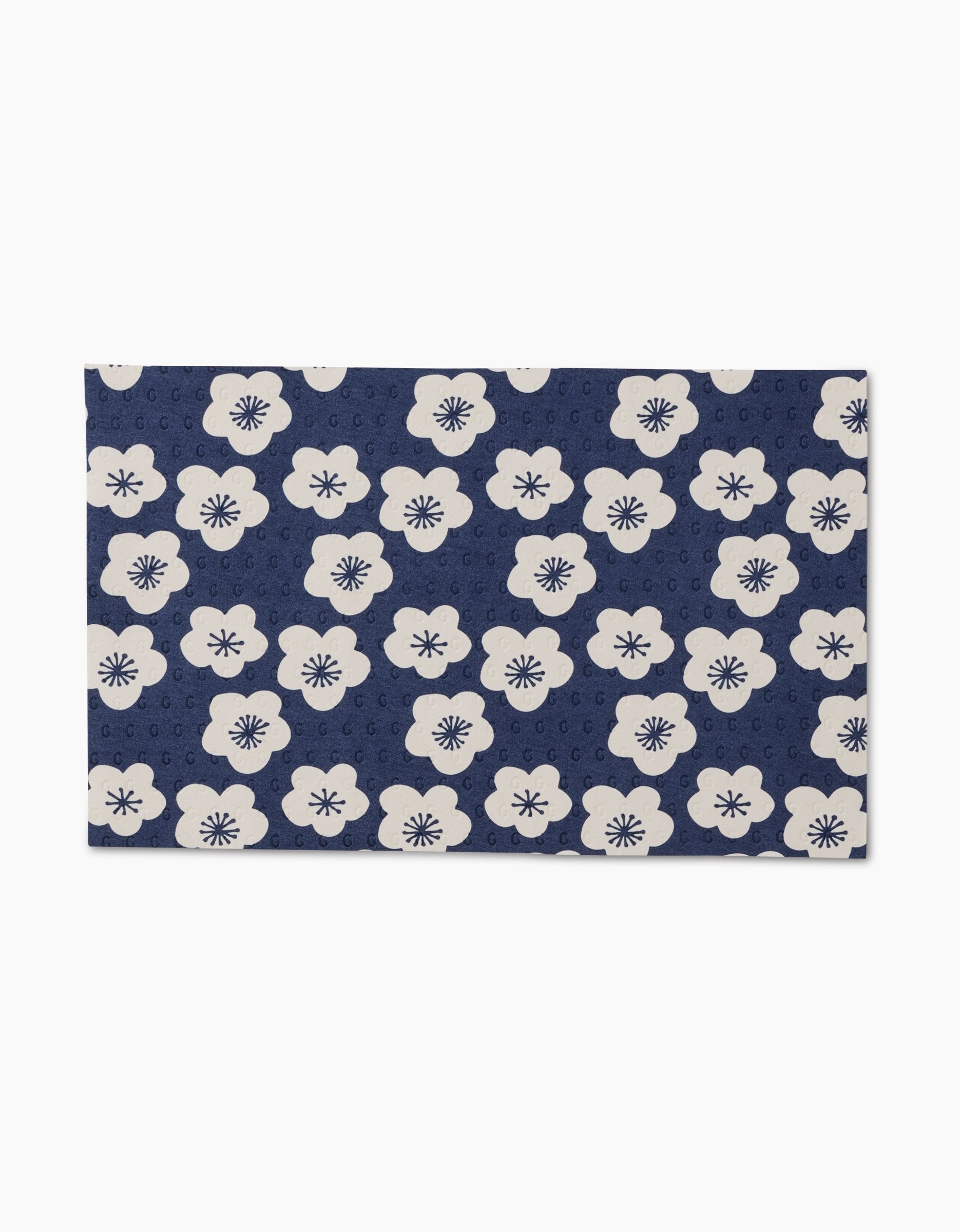Every Wish by GEOMETRY is a rectangular, reusable mat featuring white flowers with dark centers on a navy blue background, along with subtle circular motifs—an eco-friendly alternative to Not Paper Towels.