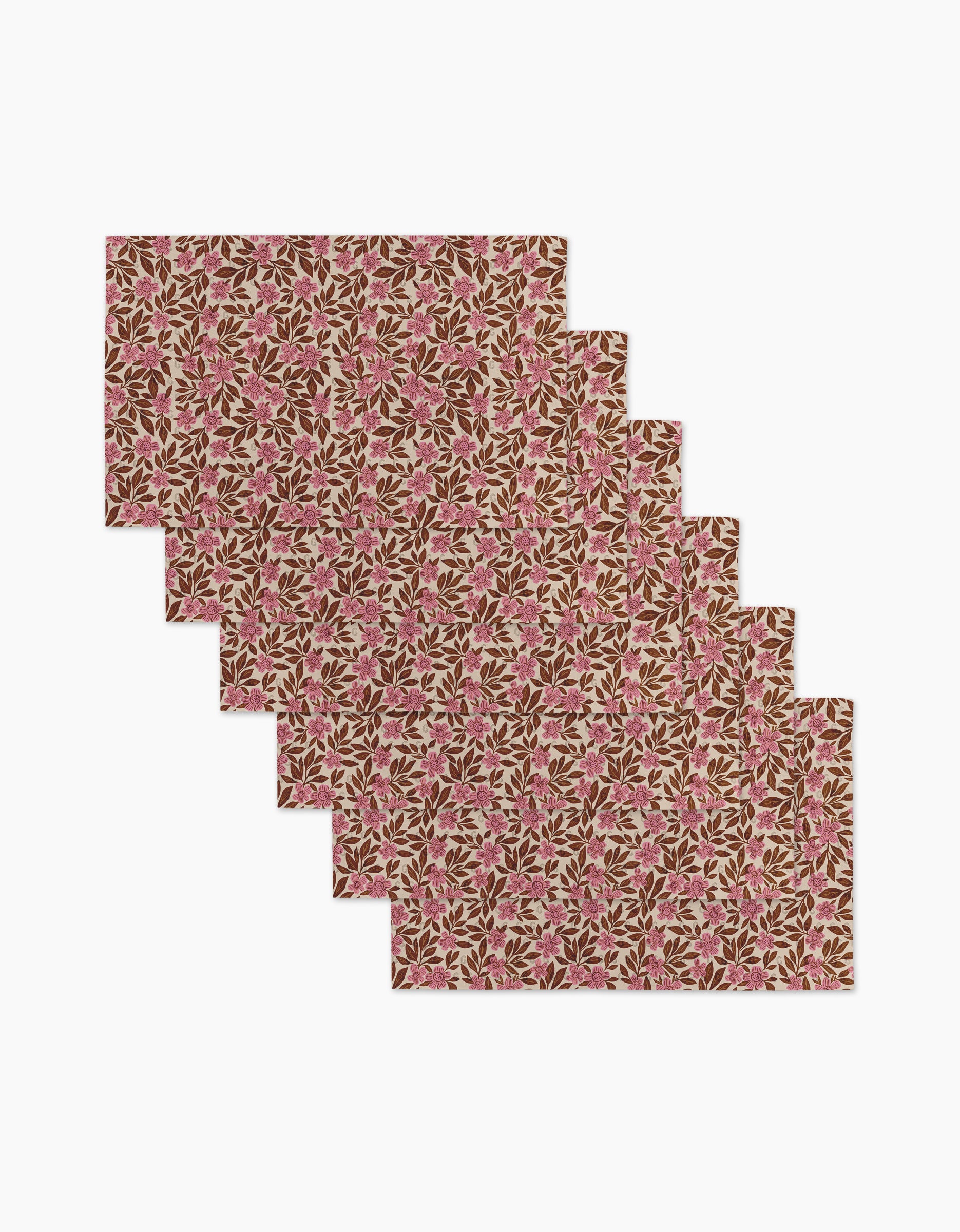 The “Floral Meadow” placemats by Lisa Nelson feature six reusable paper towels with pink flowers and green leaves on beige, arranged in a step-like display—an eco-friendly addition to your table.