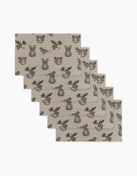 Six beige Forest Animals placemats by Rosa Kichline feature repeating cartoon faces of a bear, deer, and fox in dark brown. These eco-friendly kitchen towels are arranged in a slightly fanned-out stack.