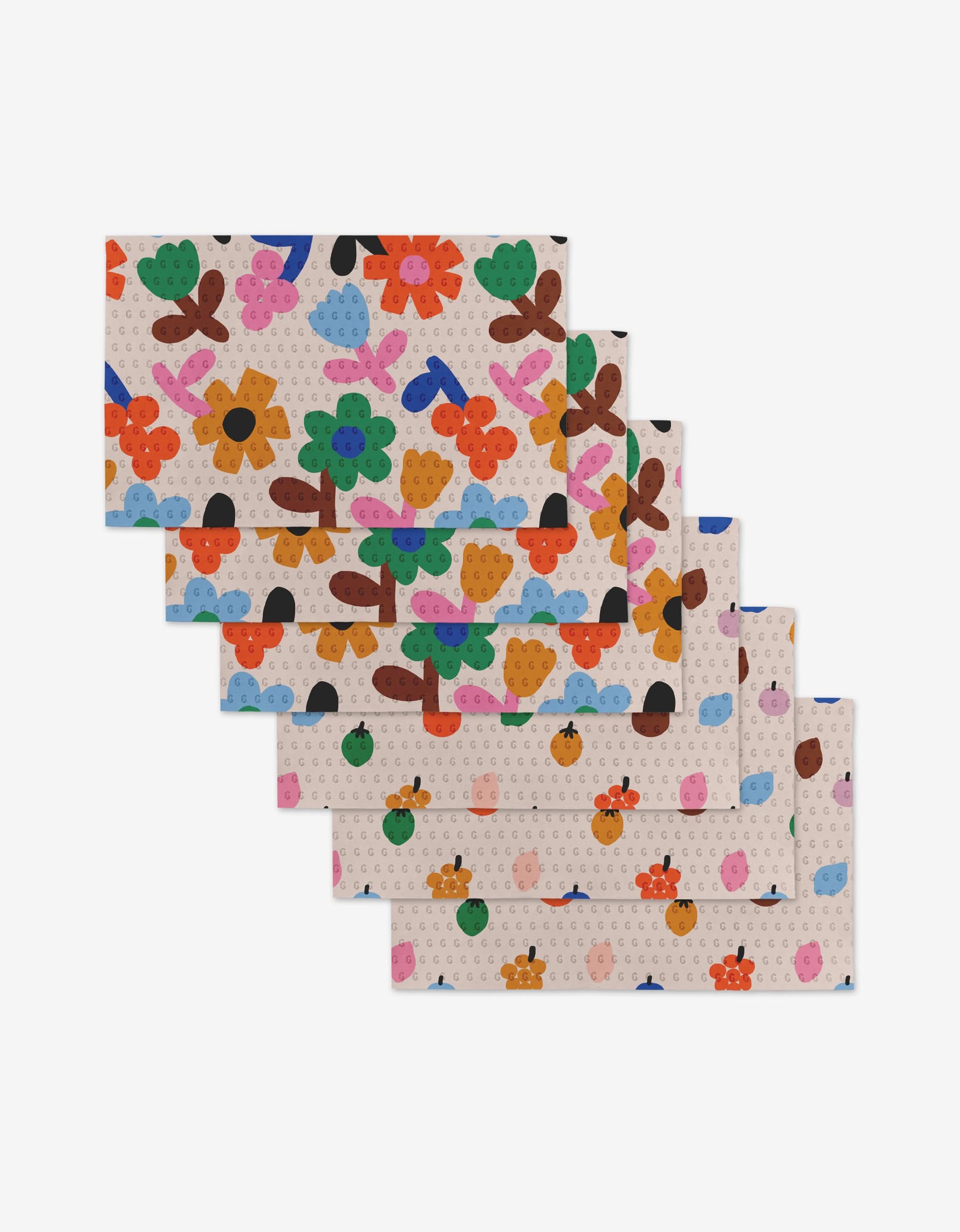 Six overlapping Fruit Basket cloths by Jennifer Bouron, featuring a colorful abstract floral pattern with red, orange, green, blue, and purple shapes on a dotted light background—a reusable, eco-friendly alternative to Not Paper Towels.