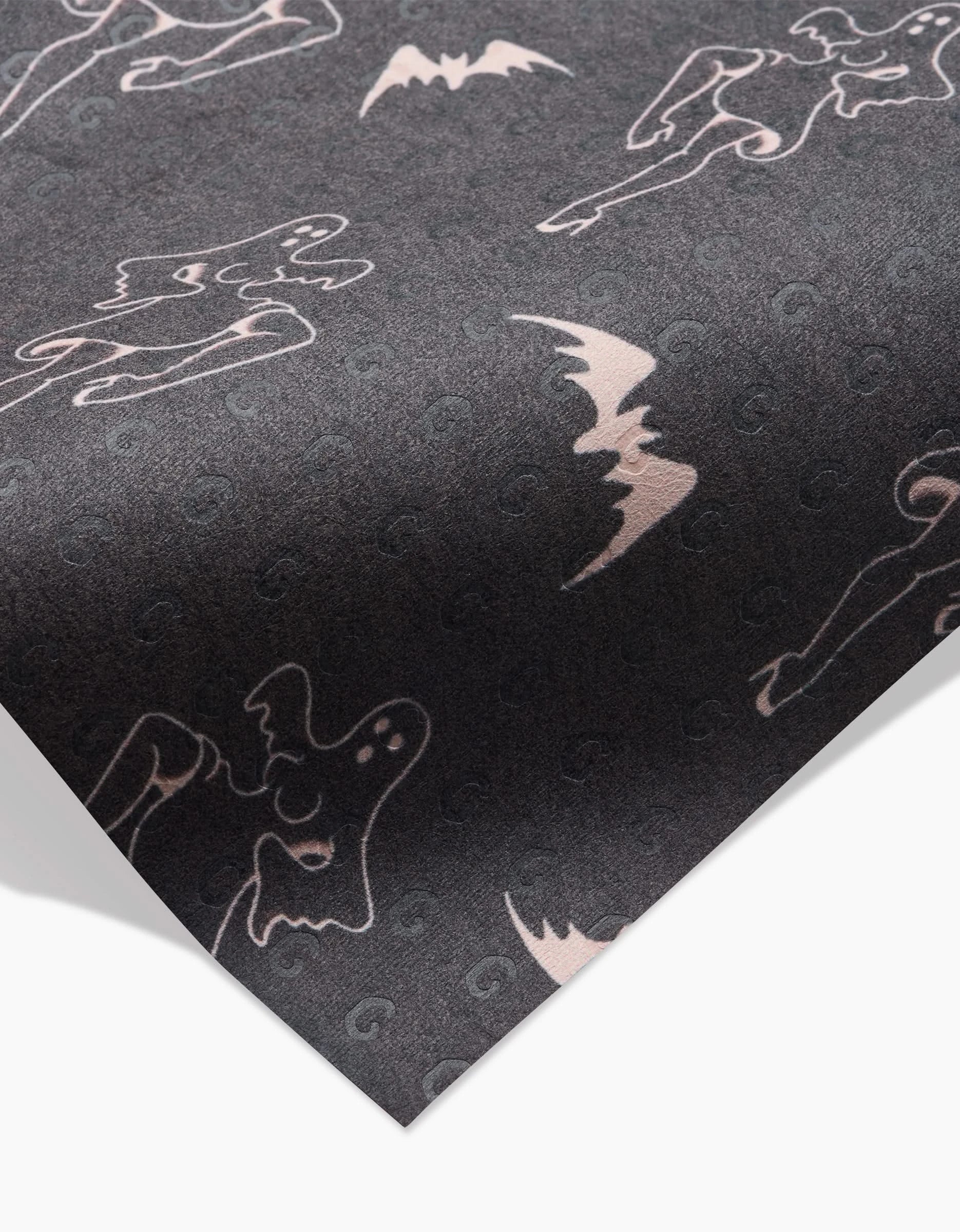 Ghost Pin Up by Cole Strem features dark gray, eco-friendly paper decorated with light pink abstract faces, figures, and bat shapes in a repeating pattern.