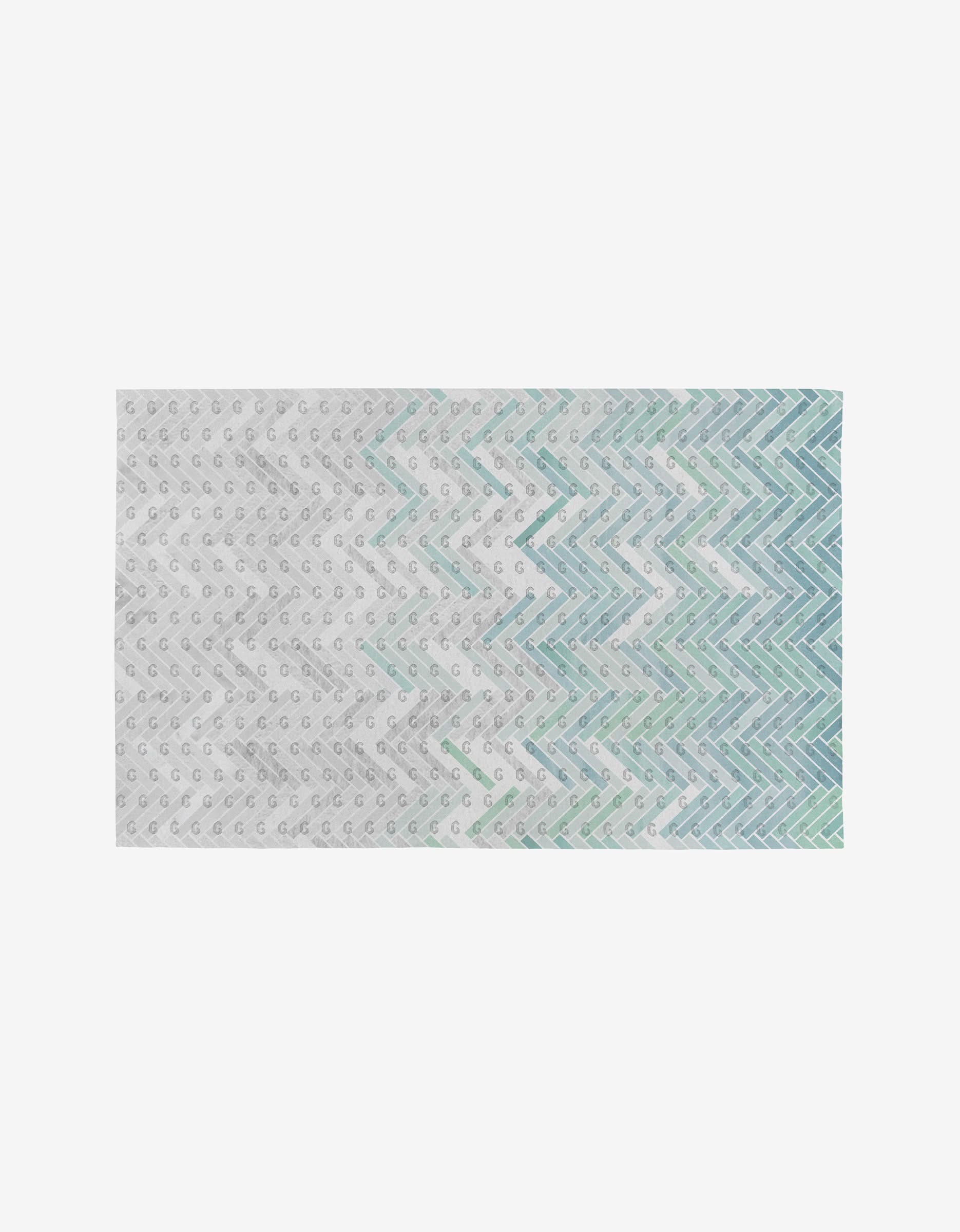 The GEOMETRY Going Up rug is a rectangular, eco-friendly piece with a white base and small gray dots, plus blue, teal, and mint green zigzag lines in a gradient. It’s reusable—unlike Not Paper Towels.