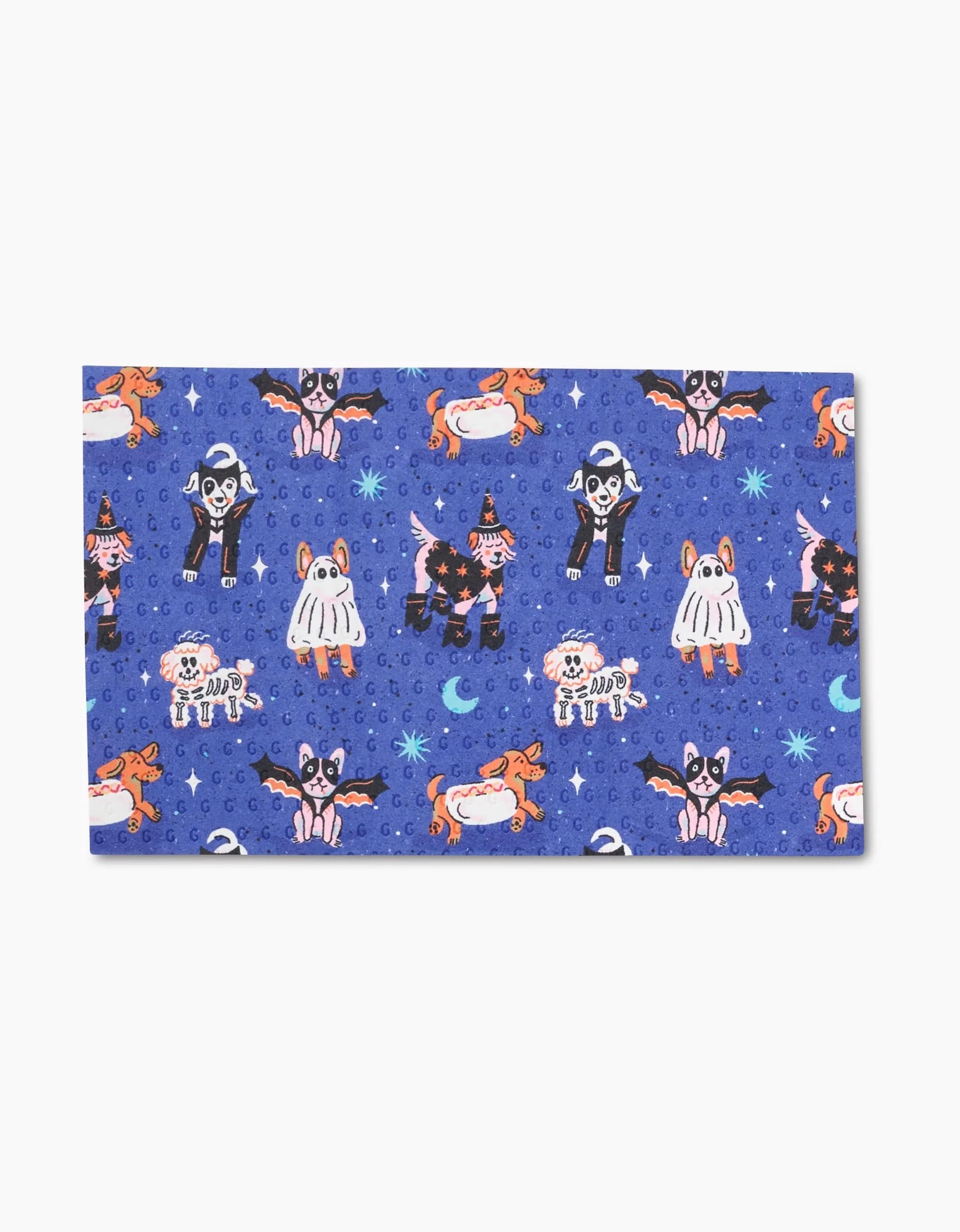The Camila Leão Halloween Hounds is a blue, rectangular eco-friendly paper towel with a repeating pattern of dogs in Halloween costumes—ghosts, witches, skeletons, bats, and pumpkins—plus stars and crescent moons.