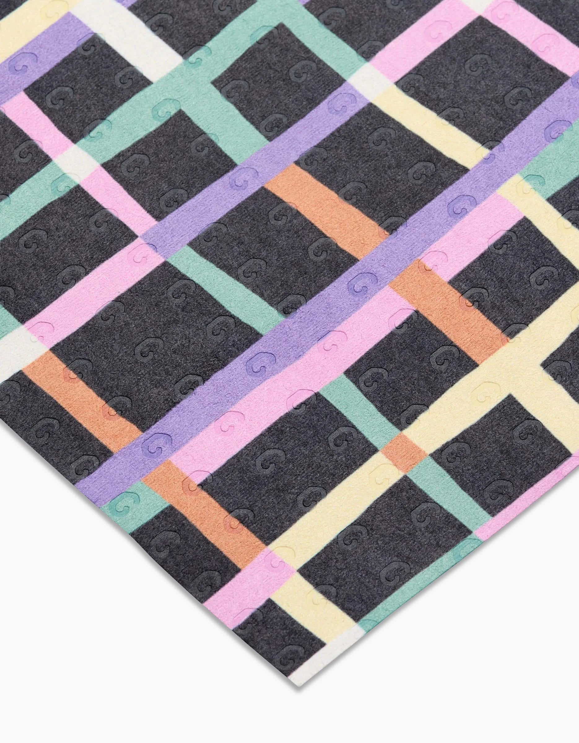 Happy Plaid by Claire Iglesias features a black background with a pastel plaid in green, yellow, pink, orange, and purple. Made from post-consumer recycled materials, it boasts subtle embossed G symbols for an eco-friendly touch.