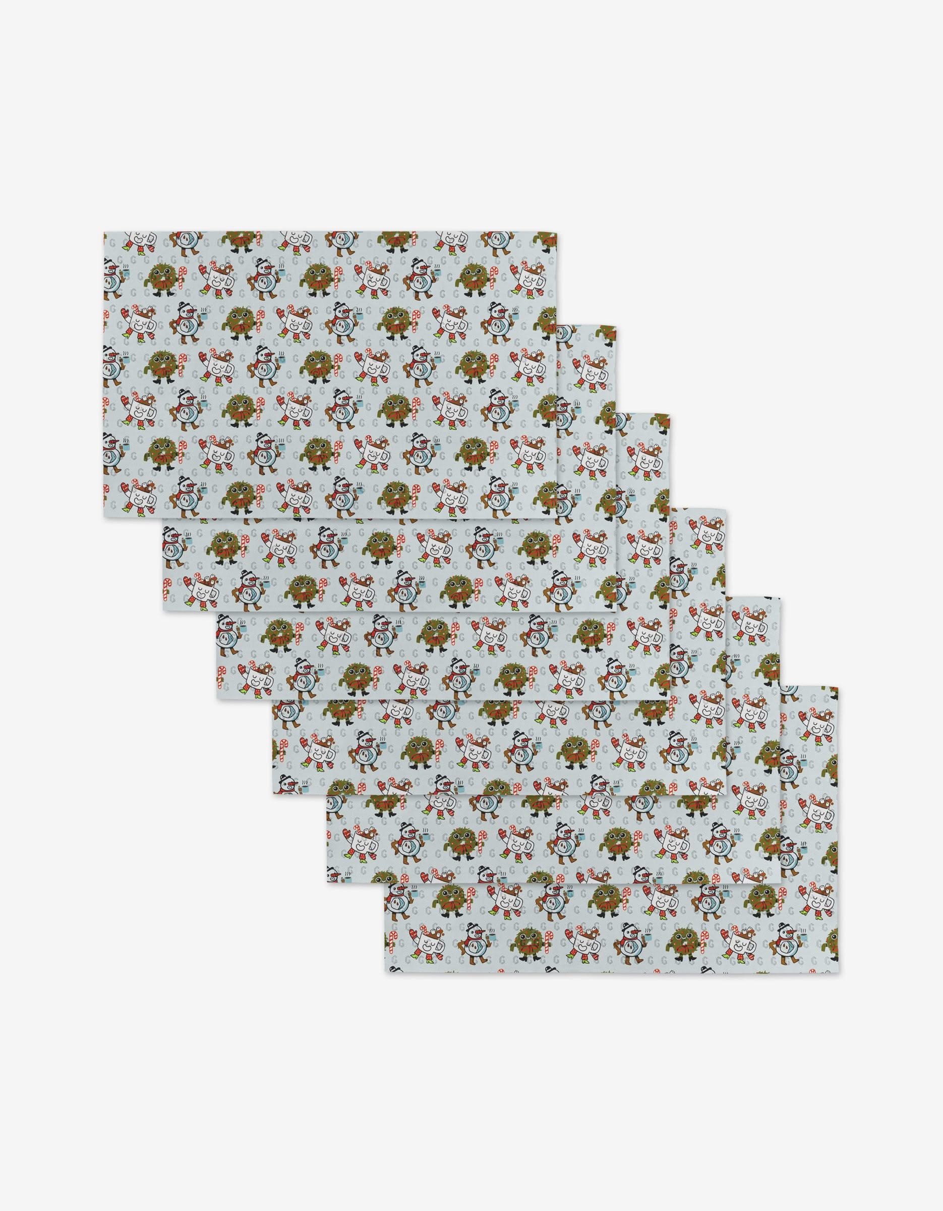Six Carly Berry Holiday Pals rectangular placemats, displaying a white base with colorful floral and leaf designs, are arranged in a staggered stack on a white background. These mats are reusable and eco-friendly—not paper towels.