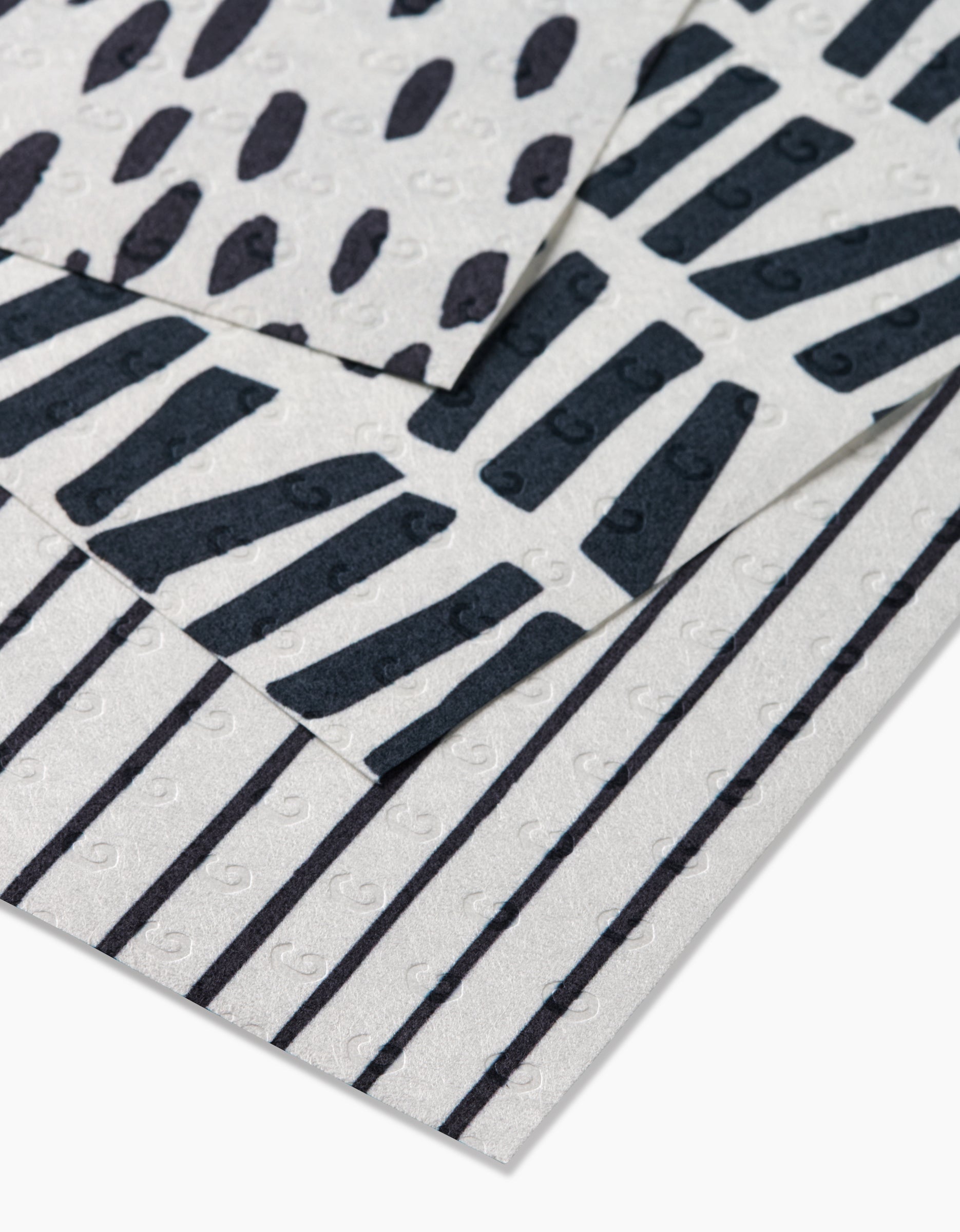Three Lines, Dots and Dashes sheets by GEOMETRY feature black dots, diagonal lines, and vertical stripes on subtly swirled white backgrounds. Made from eco-friendly post-consumer recycled materials.
