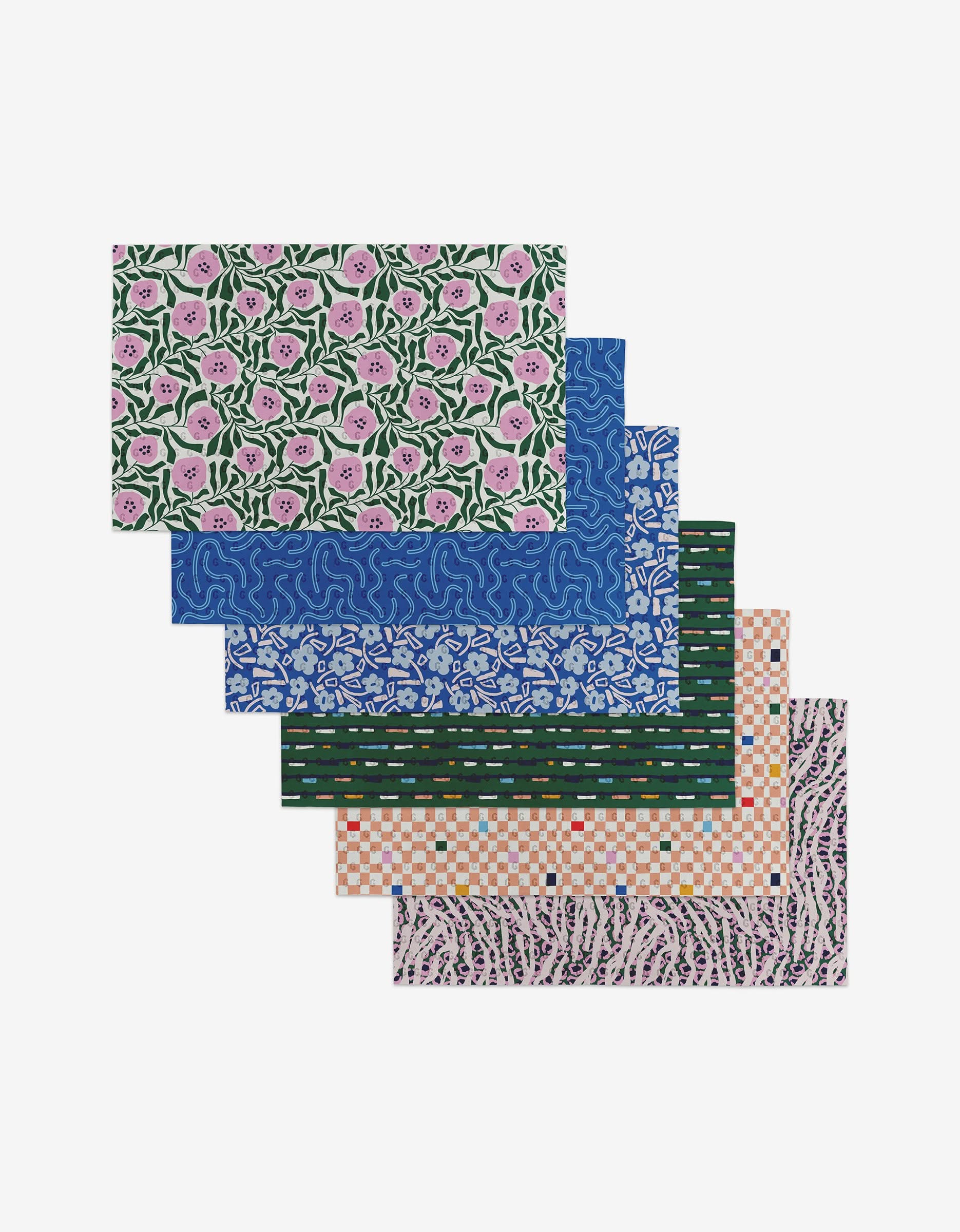 Six Magic Field placemats by Happy Hemera, crafted from post-consumer recycled materials, feature vibrant floral, abstract squiggle, geometric, and mosaic patterns—an eco-friendly and stylish addition to your table.