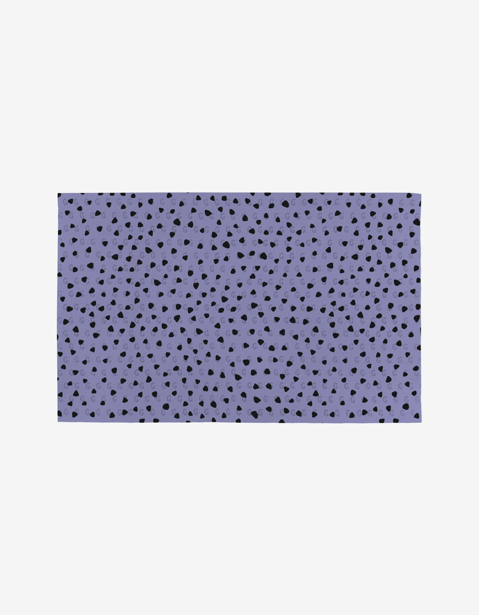 The Magic Spells mat by Hufton Studio features a purple background with an irregular pattern of small black spots, resembling terrazzo or confetti. Made from post-consumer recycled materials, it is shown against a plain white background.