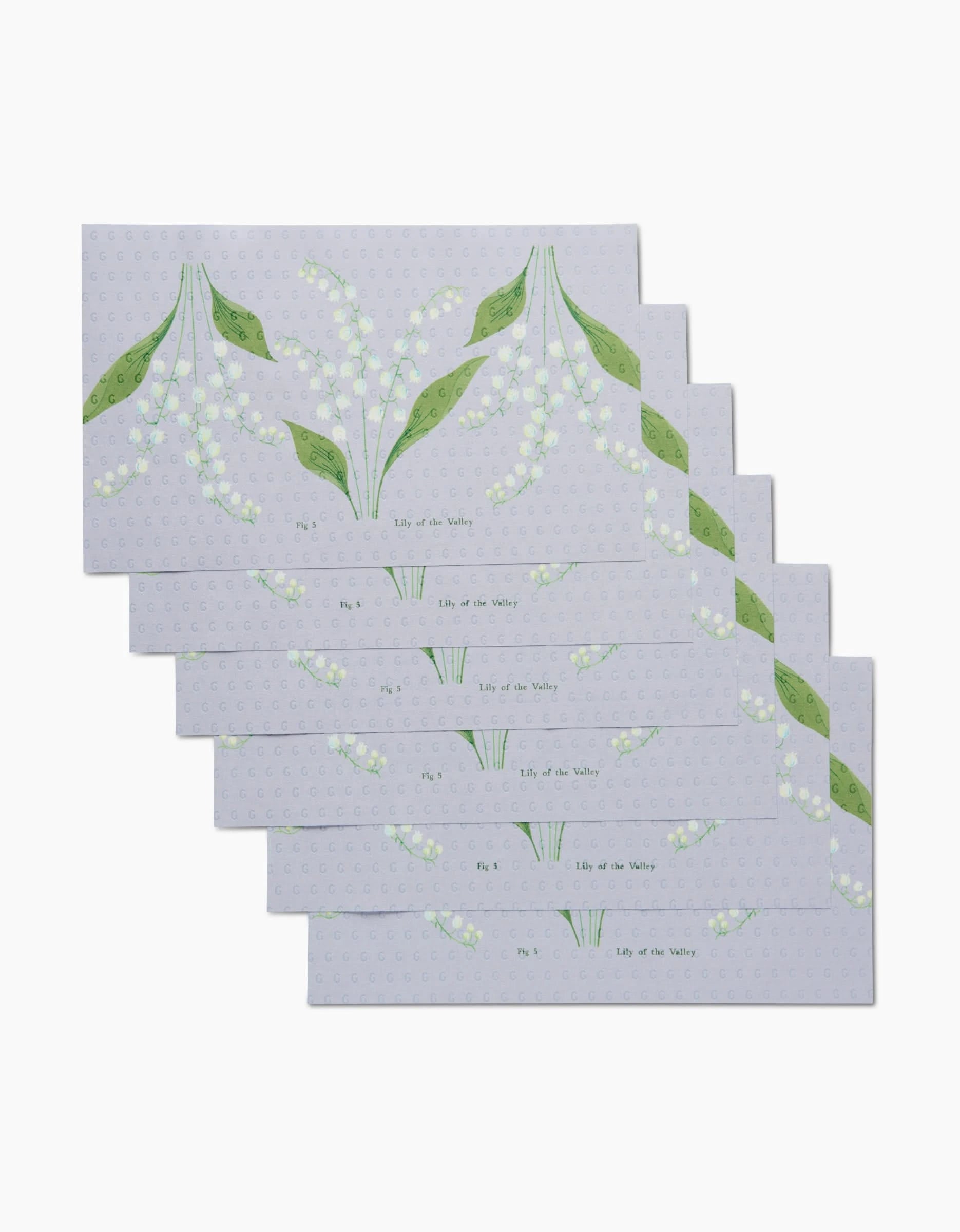 Six reusable rectangular May Lily Of The Valley cards by Linda Fox, featuring lily of the valley flowers and green leaves, fanned out on a light dotted background—an eco-friendly choice.