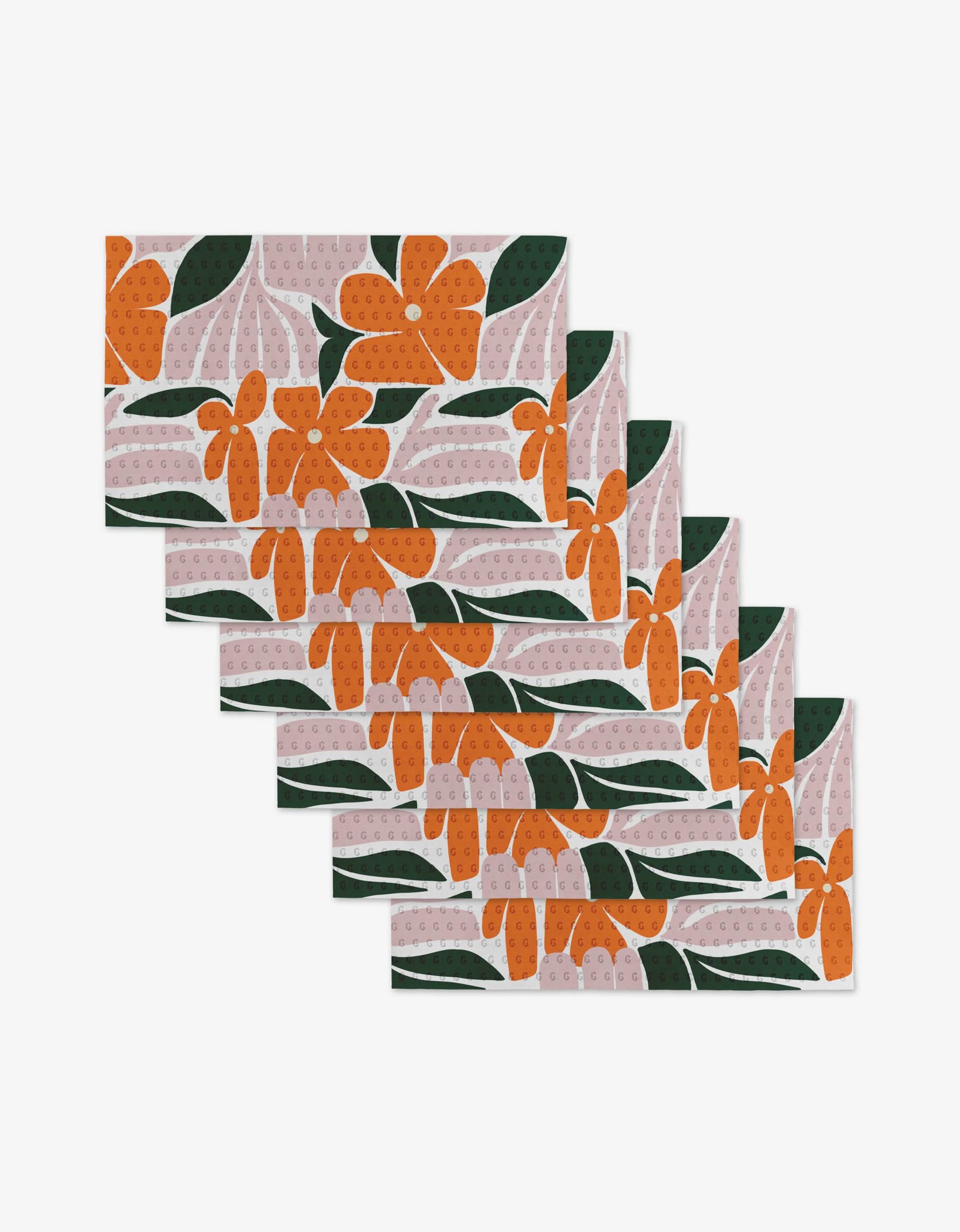 Lisa Nelson’s Modern Floral set includes six reusable rectangular placemats with an orange floral and green leaf pattern on light pink—a stylish, eco-friendly alternative to paper towels.