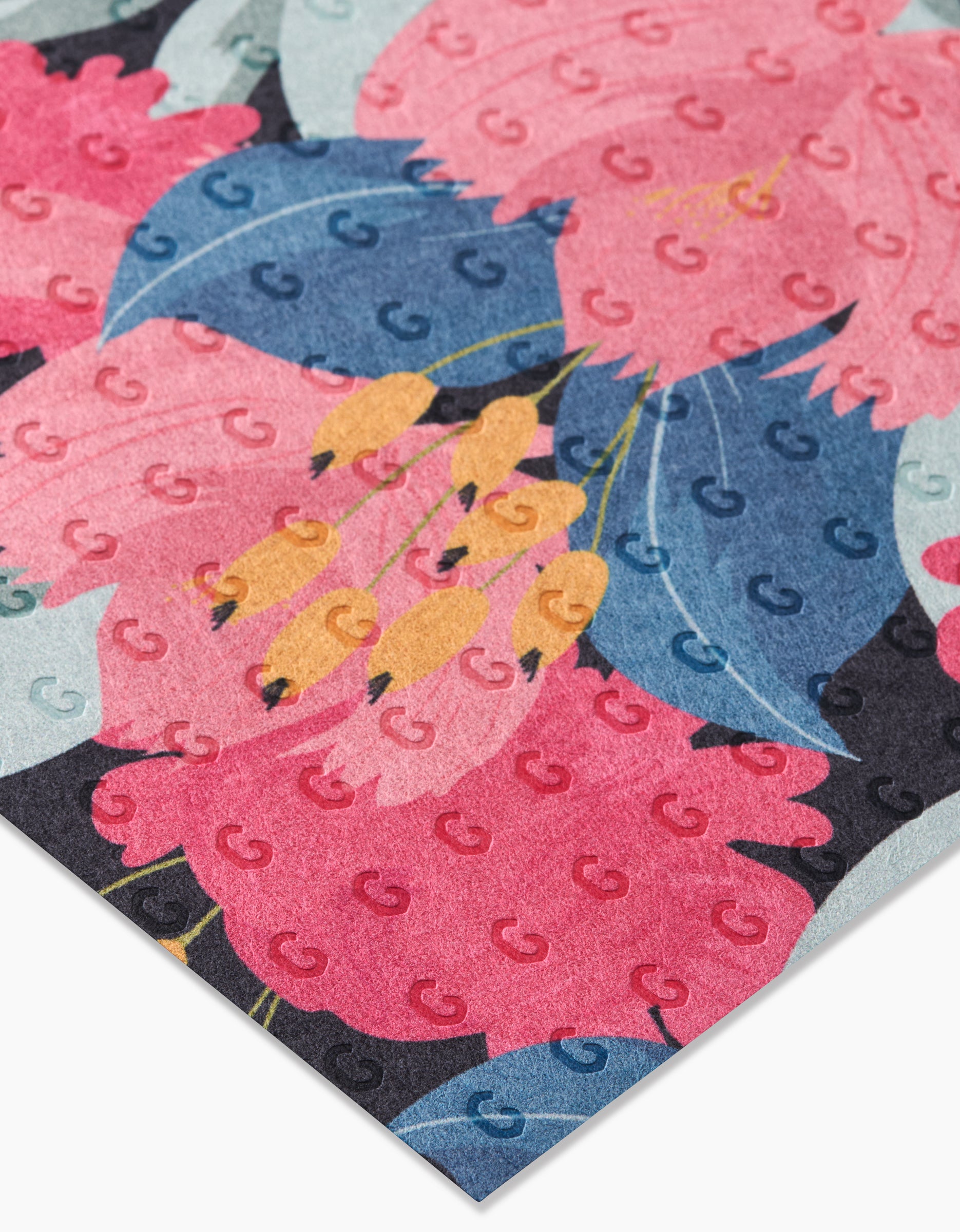A close-up of GEOMETRY’s My Garden reusable towel, featuring a vibrant floral pattern with large pink and yellow flowers, blue leaves, and subtle repeating G logos—an eco-friendly Not Paper Towel alternative.