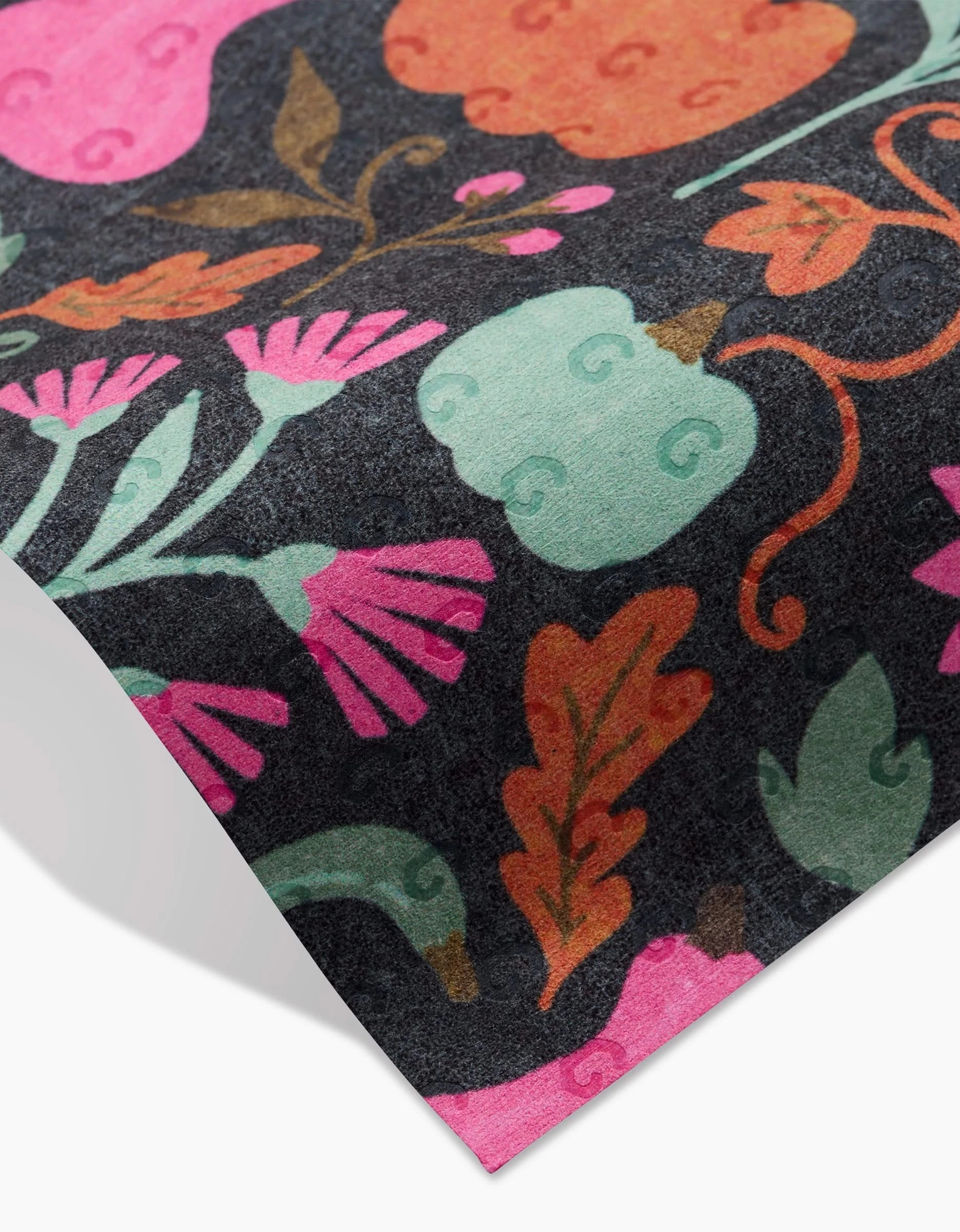 A close-up of the Oakley fabric by Amy MacCready, displaying pink flowers, teal pumpkins, and orange leaves on a dark background—ideal for stylish, eco-friendly kitchen or reusable paper towels.