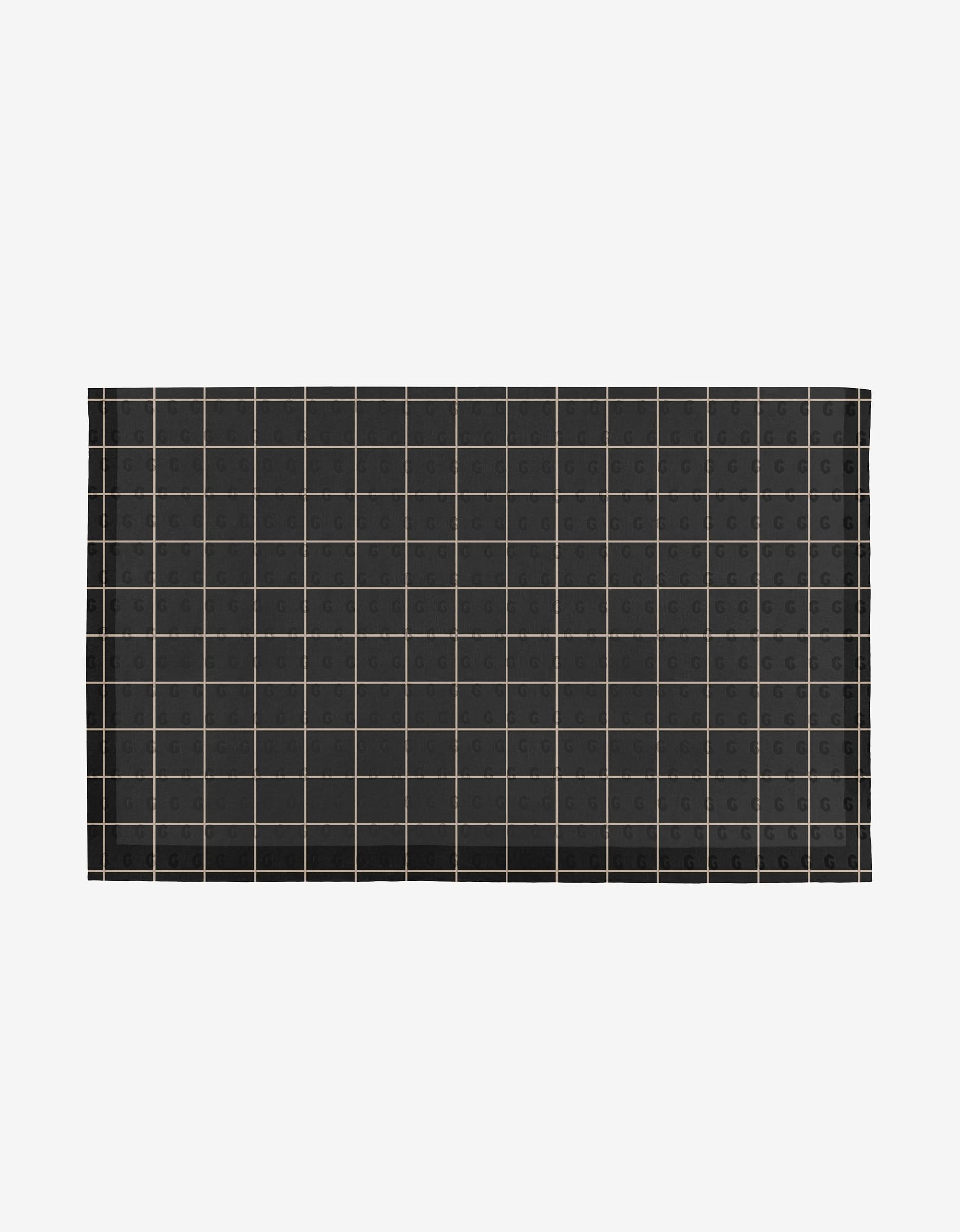 The Plant One on Me mat by Aubrey Fairchild is a rectangular black mat with a grid of thin light lines and small G symbols in each square, made from eco-friendly post-consumer recycled materials. Displayed on white. Not Paper Towels.