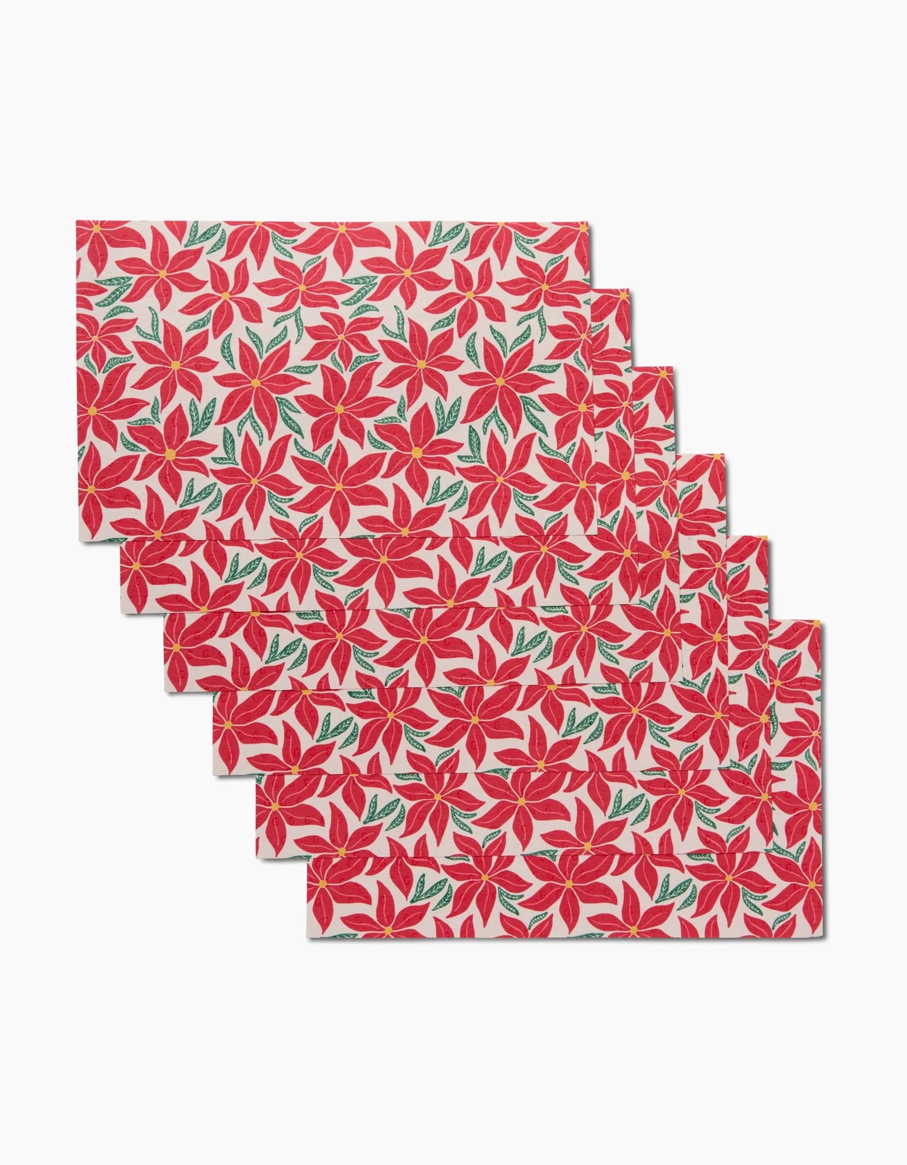 The Kayla Ann Poinsettia Party set includes six rectangular placemats with a red poinsettia and green leaf design on white, offering an eco-friendly, machine-washable alternative to disposables.