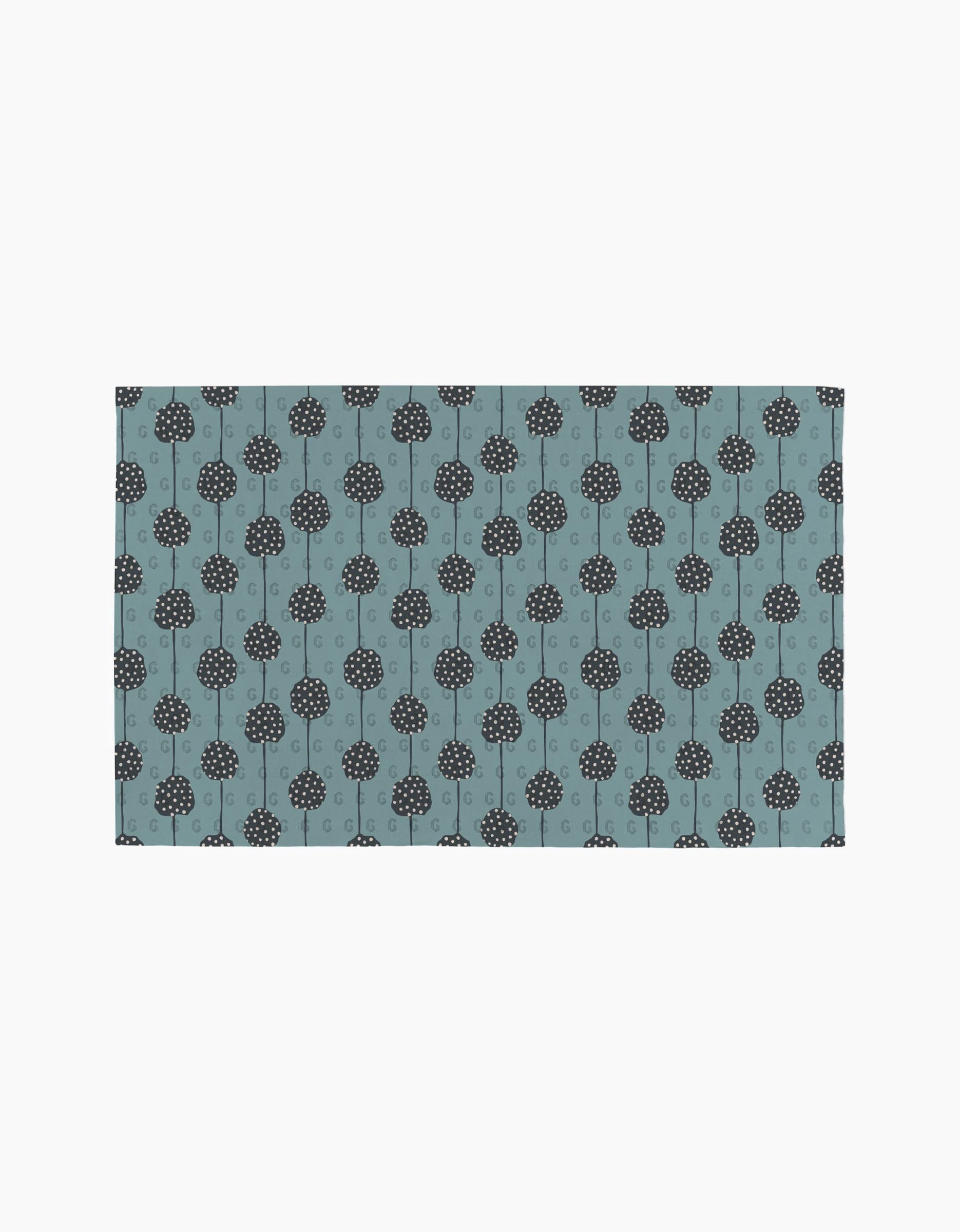 Polka Dot Blooms by Lizzie Clark is a rectangular mat featuring evenly spaced, simple black stylized trees on a muted blue background. This minimalist design brings eco-friendly, sustainable style to any space.