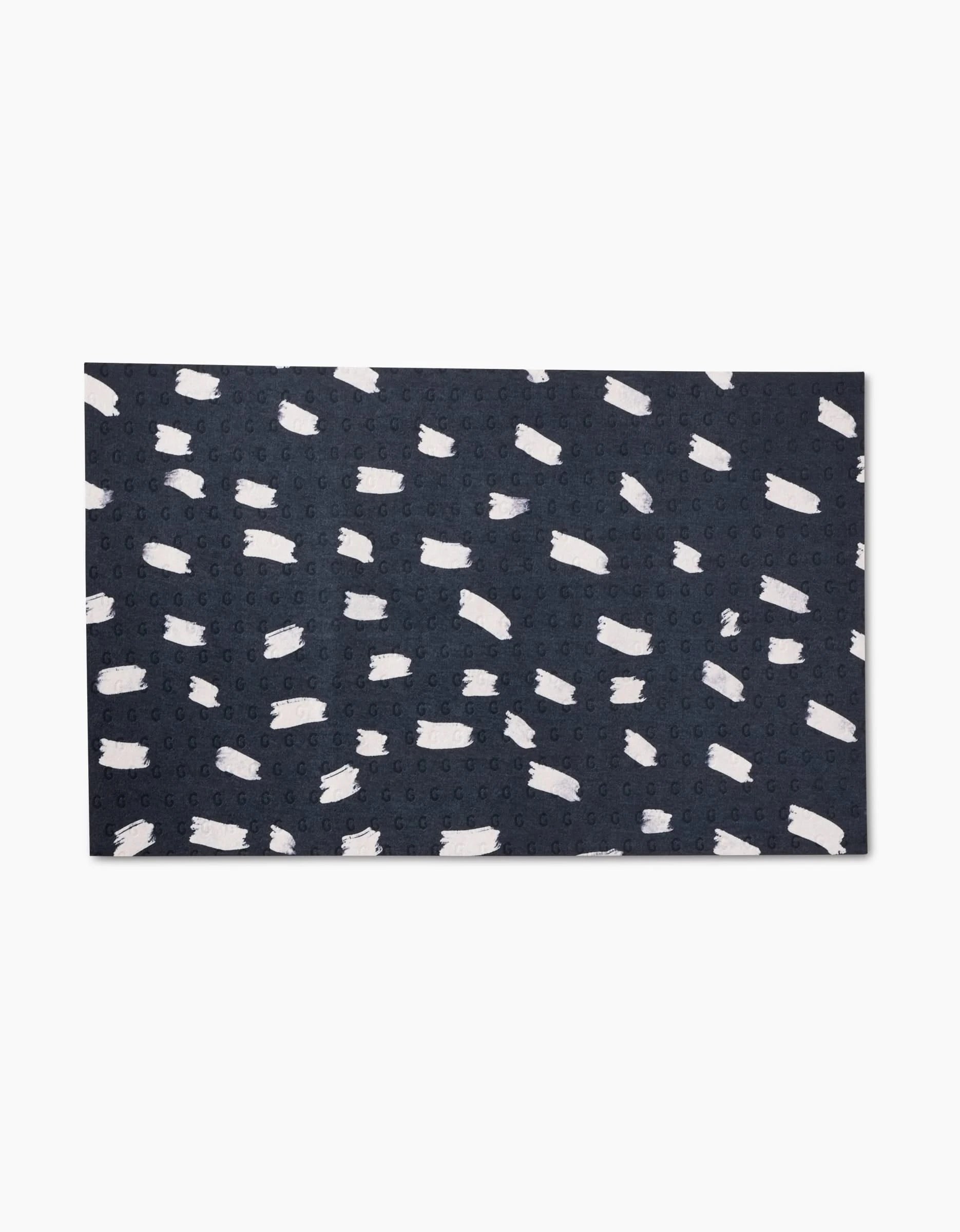 The GEOMETRY Pop Of Color rug features a rectangular dark blue design with abstract white brushstroke patterns, crafted from post-consumer recycled materials for an eco-friendly alternative to standard rugs.