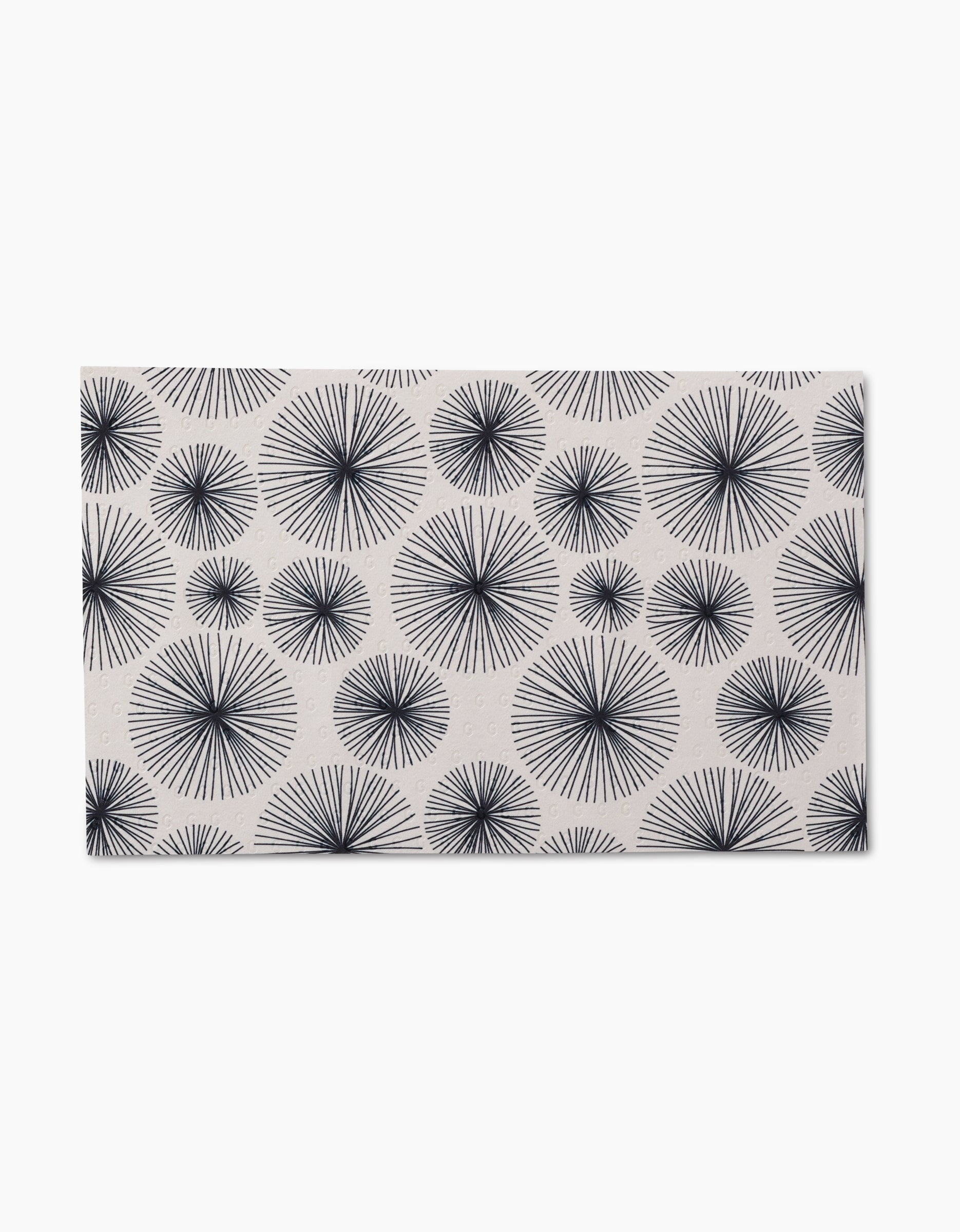 The GEOMETRY Pop Of Color mat is rectangular with a white background and a repeating pattern of black starbursts in various sizes, crafted from post-consumer recycled materials for an eco-friendly touch.