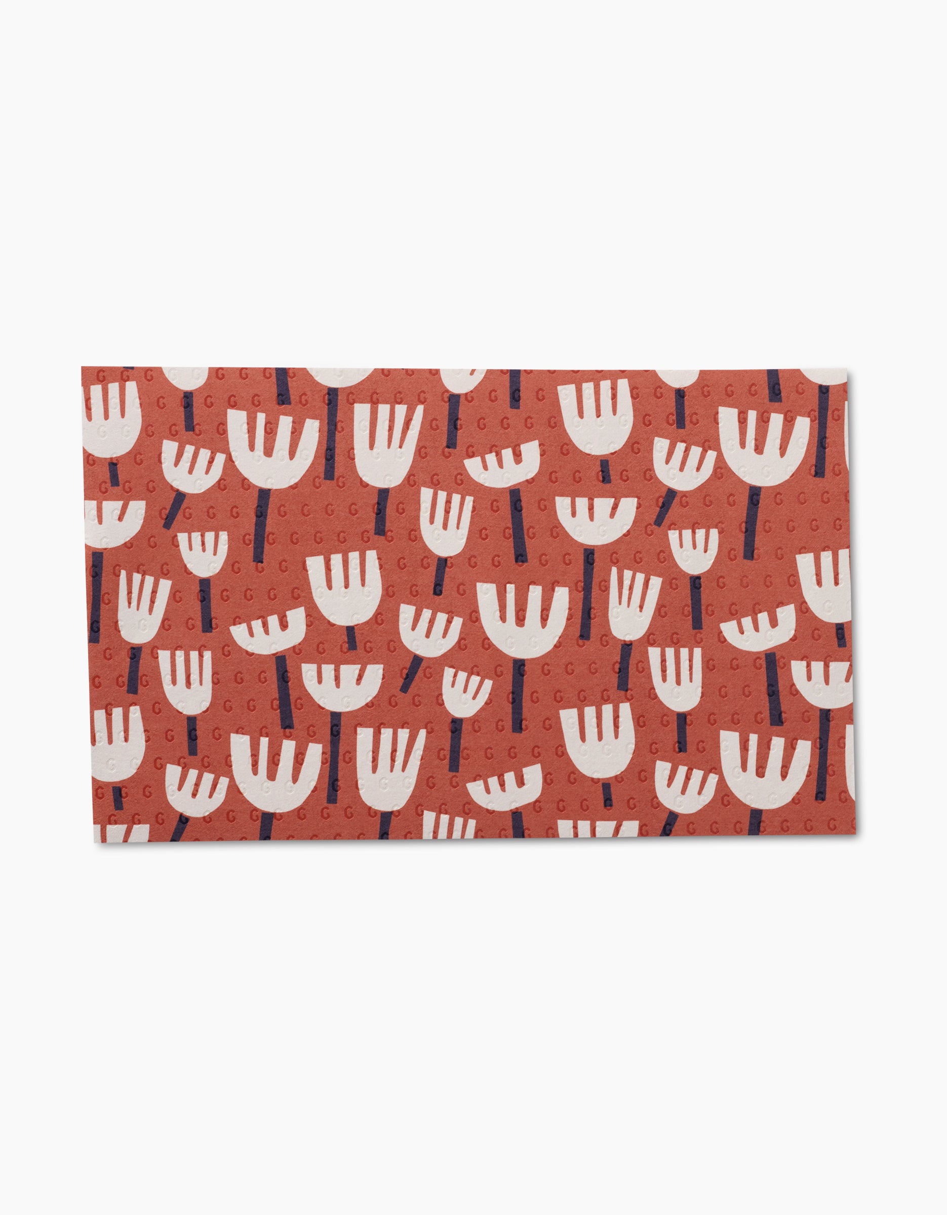 Claire Iglesias’ Rainbow Cutouts is a rectangular mat with a red background, repeating stylized white flowers with blue stems and circular designs, crafted from post-consumer recycled materials for eco-friendly cleaning.