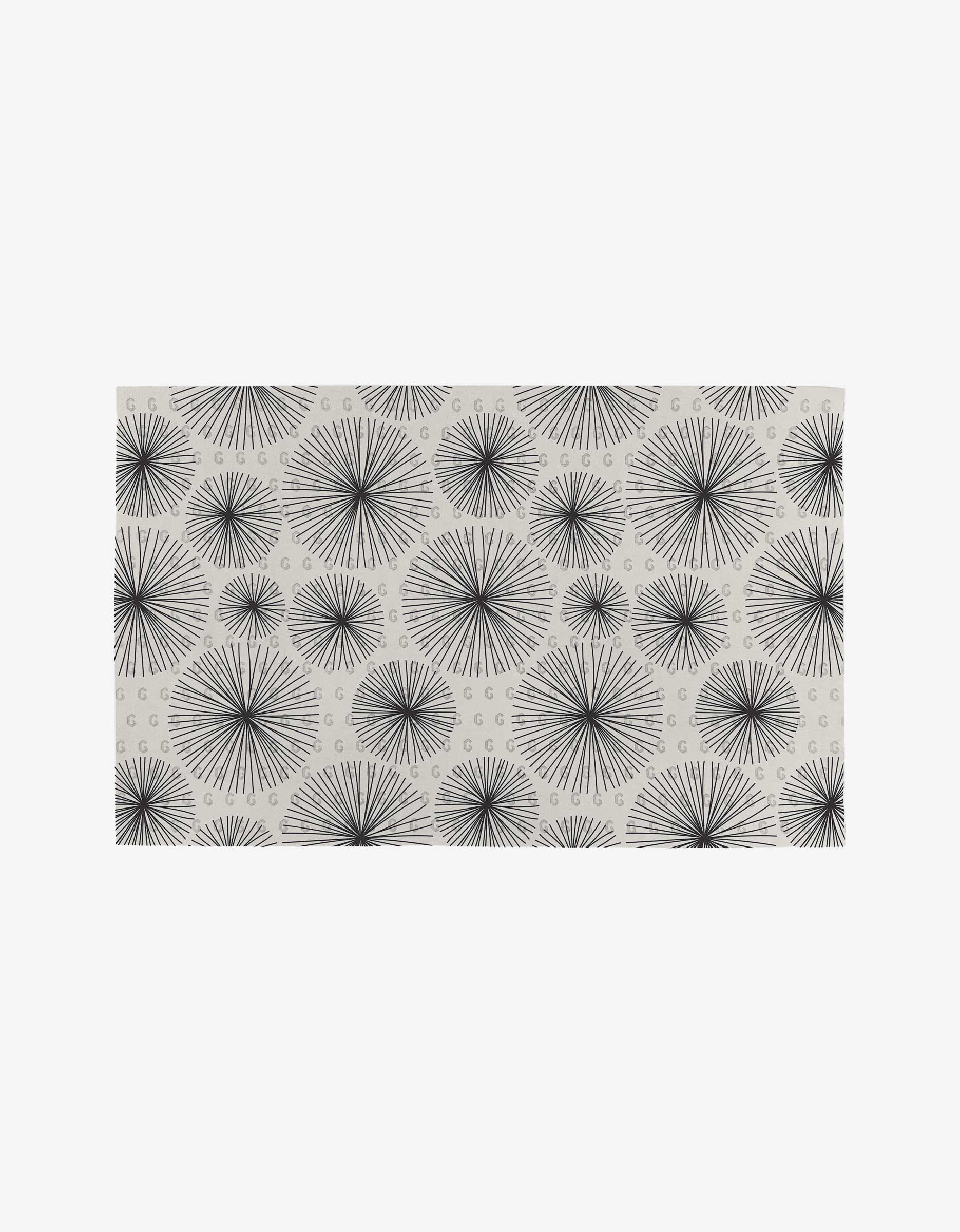 The GEOMETRY Sky Party rug features a white background with black starburst patterns and curved lines, all crafted from eco-friendly recycled materials.