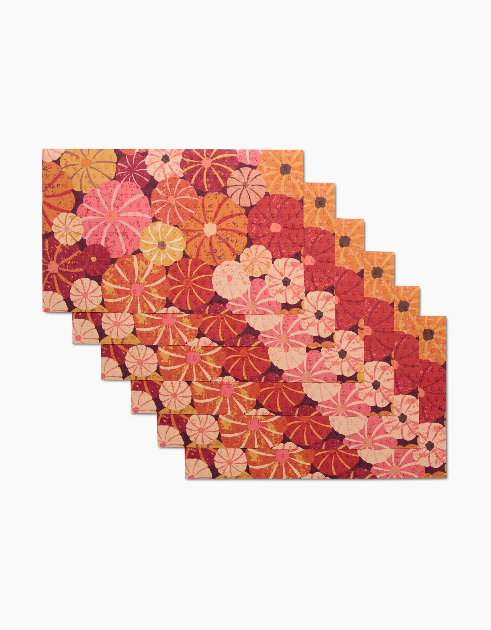 The Spicy Pumpkins rug by Rebecca Bobko features vibrant red, pink, orange, and yellow circular patterns on white with a stepped edge—its mosaic look pairs perfectly with eco-friendly kitchen towels for a coordinated, lively space.