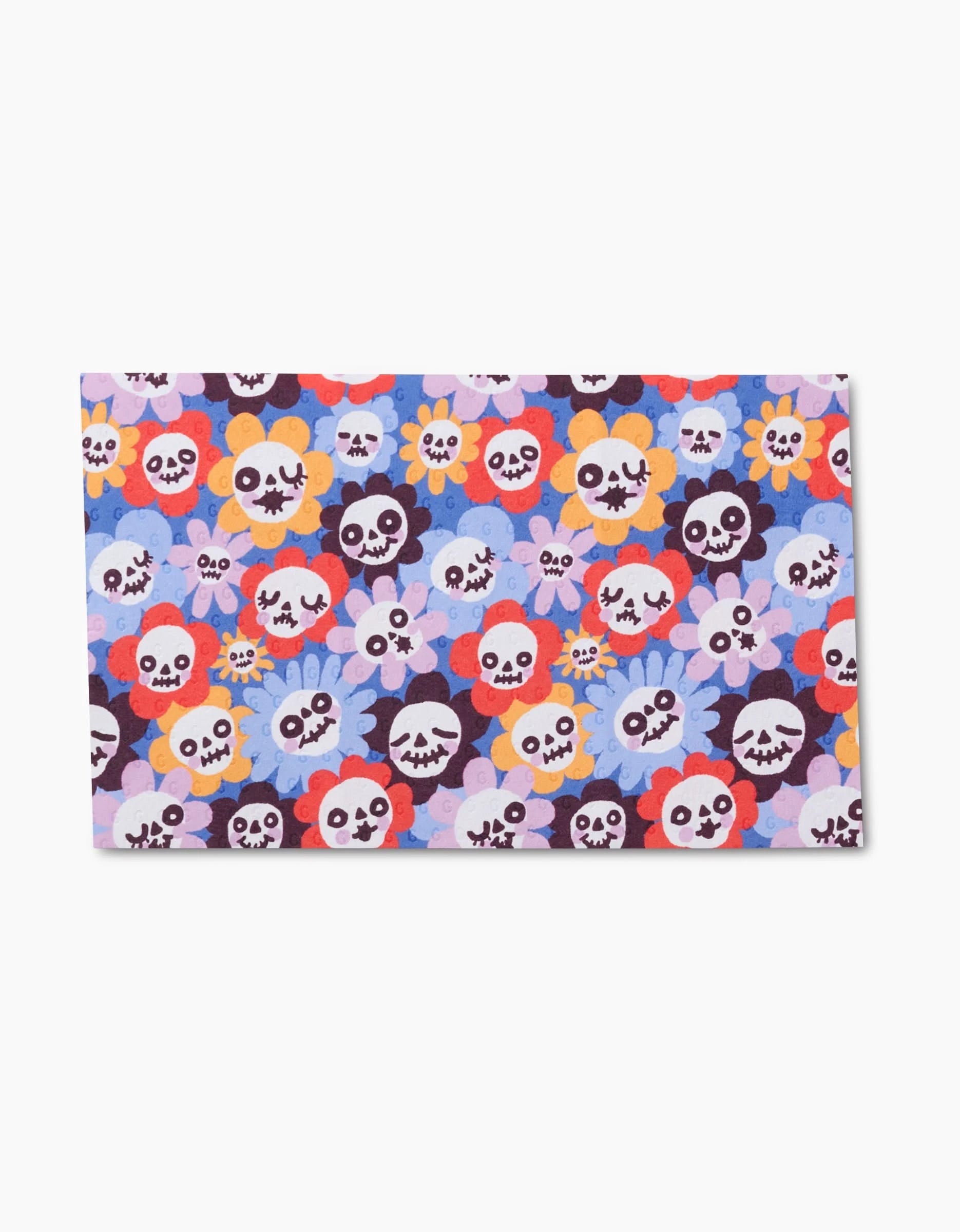 The So Lazo Spooky Bouquet kitchen towel features vibrant rectangular eco-friendly fabric with cartoon skulls in playful expressions and flower-shaped backgrounds in purple, blue, red, orange, and pink.